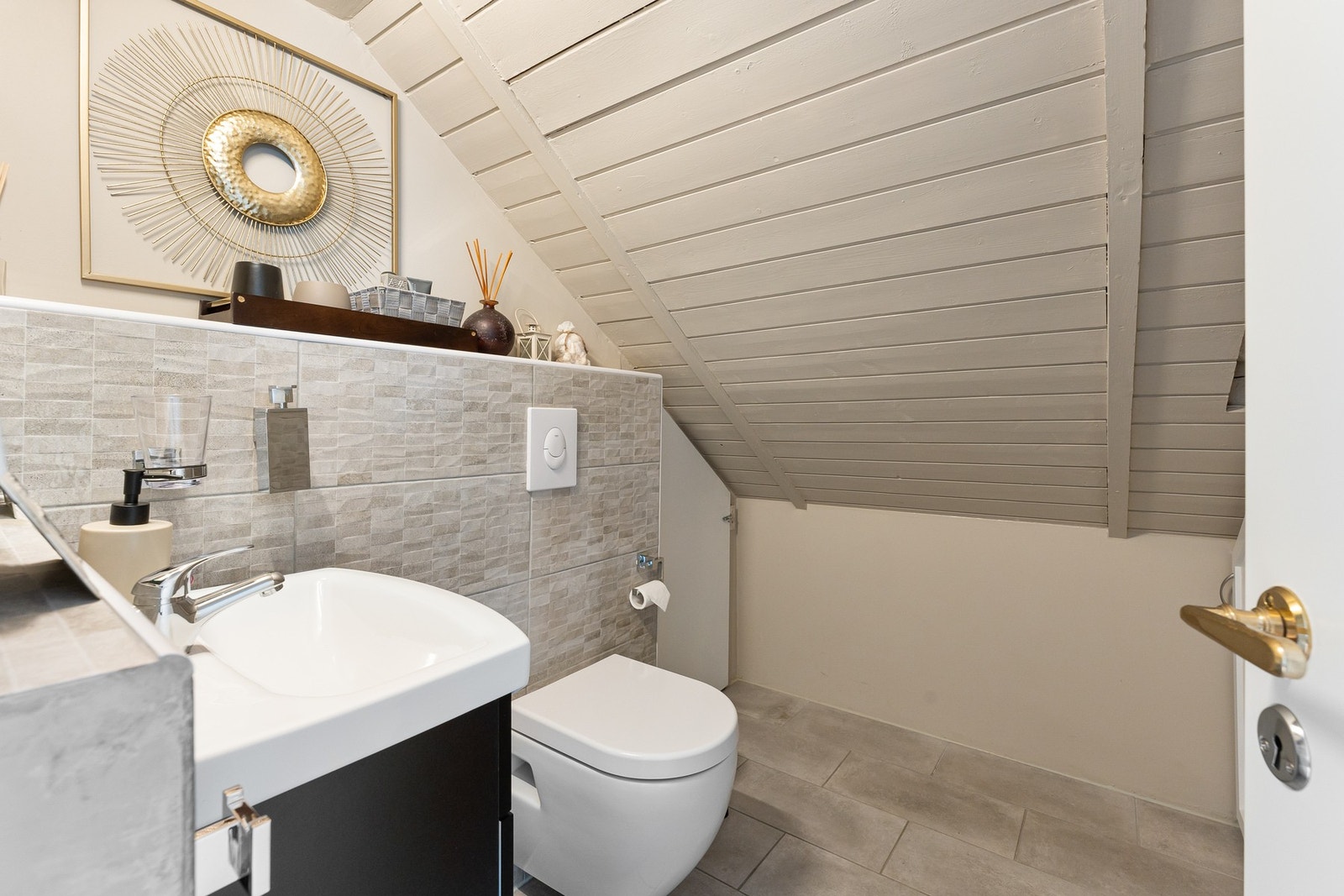 Kasse med toalett og servant er flislagt med lekkre fliser Galleribilde