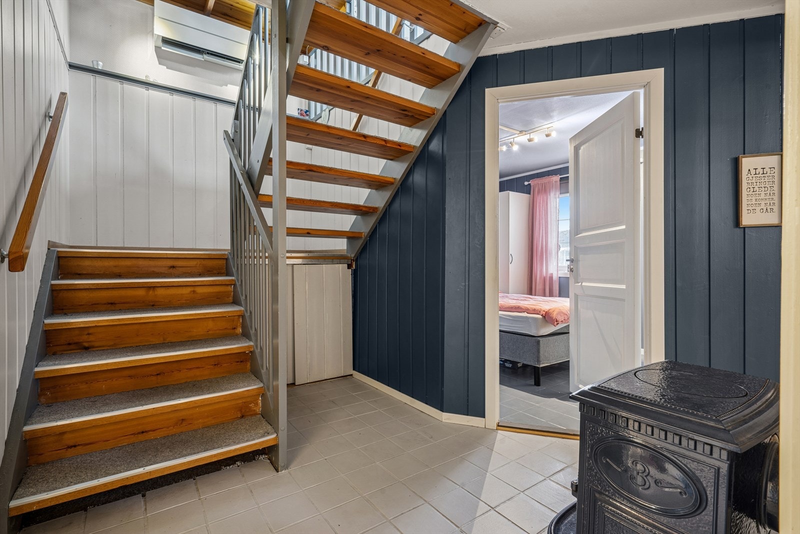 Flislagt trappegang med vedfyrt ovn i sokkeletasjen. Galleribilde