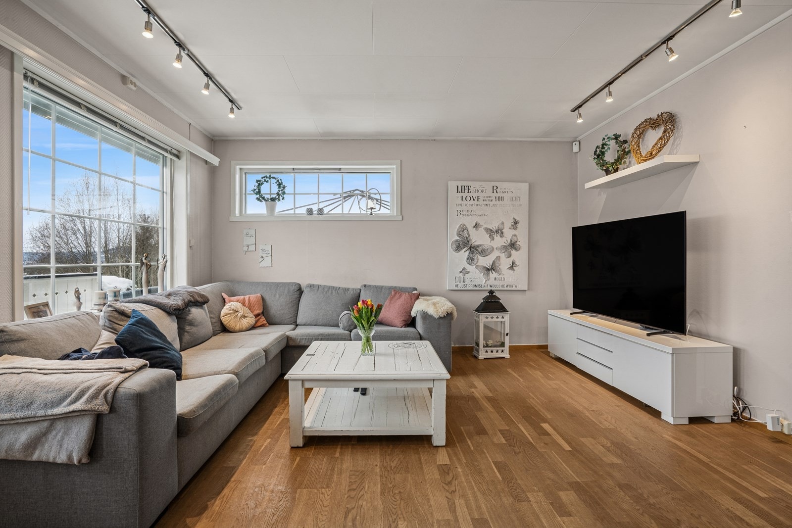 Sofa og TV har sin naturlige plassering i den andre enden av stuen. Godt lysinslipp gjennom de store vindusflatene. Galleribilde