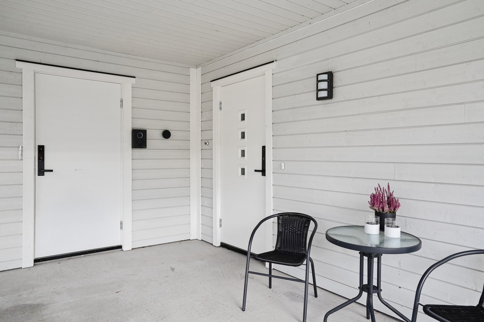 Inngangsparti med overbygg og støpt dekke. Tilkomst fra carport. Inngang til sportsboden til venstre. Begge dørene har montert elektrisk lås. Galleribilde