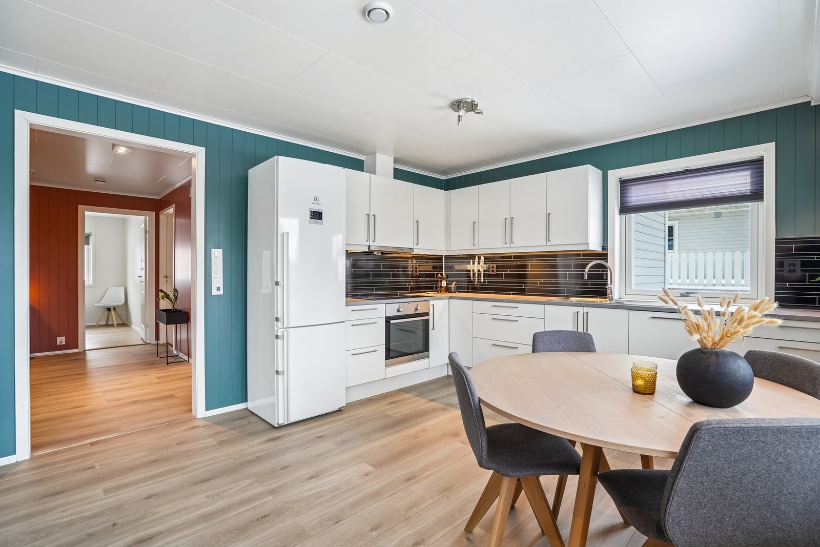 Kjøkkenet har en tidløs innredning med glatte fronter og benkeplate i laminat. Galleribilde