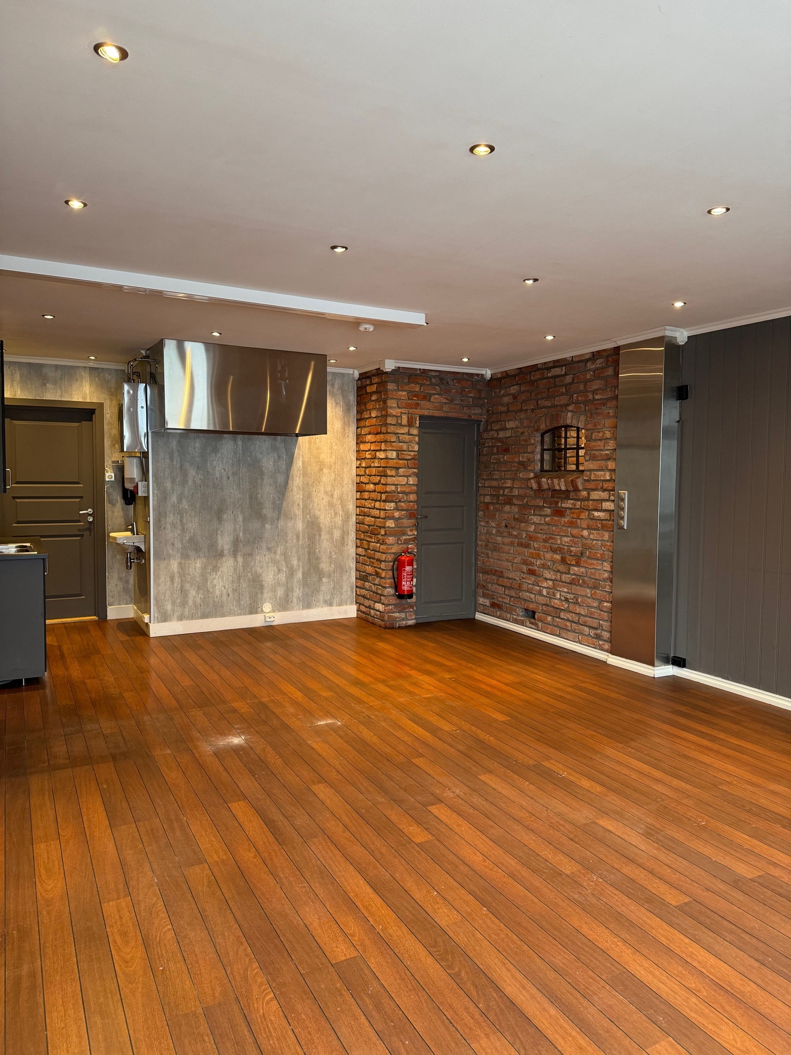 Kontrastvegg i gammel teglstein innerst i lokalet Galleribilde