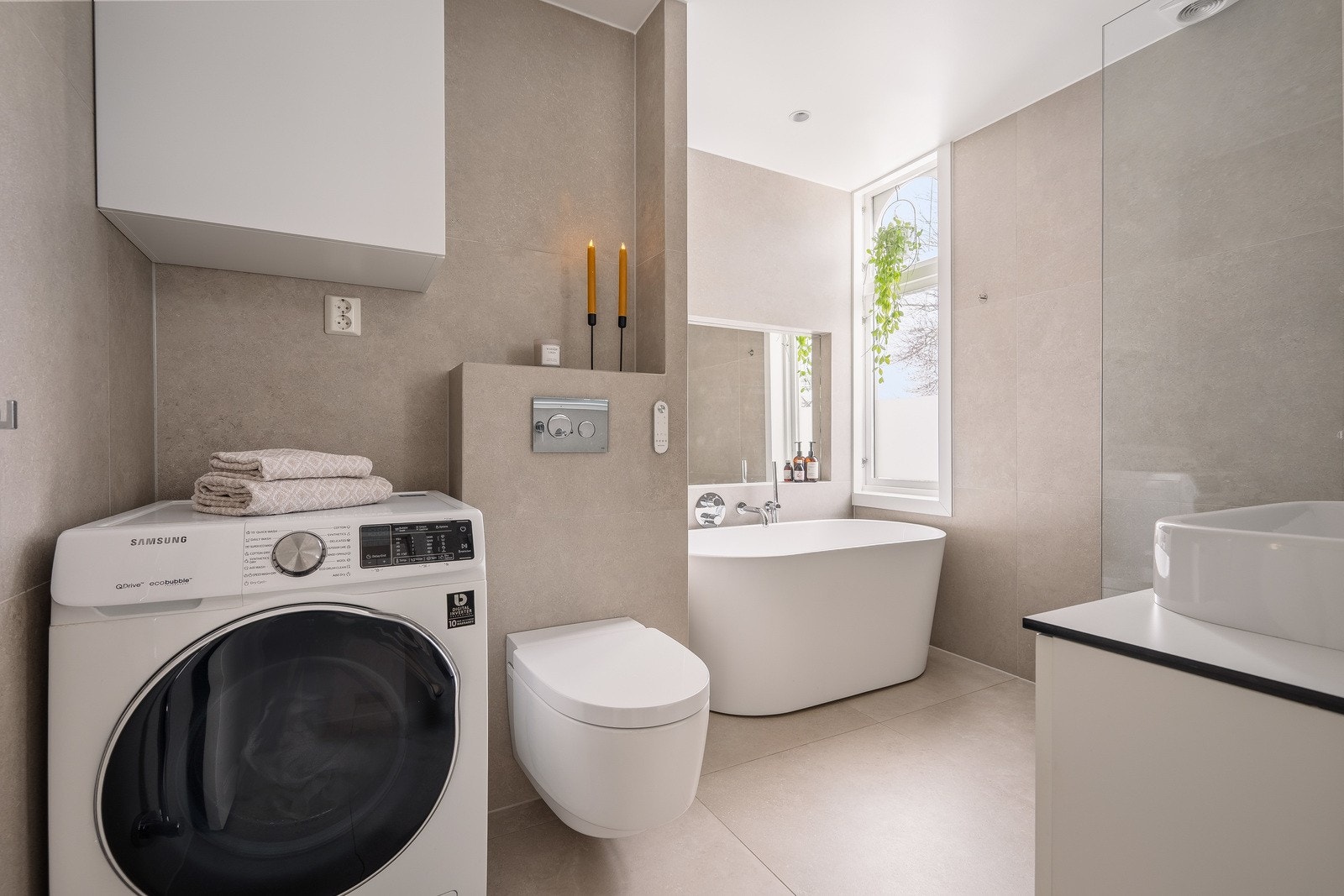 Det er varmekabler i gulvet og praktisk opplegg for vaskemaskin på badet. Galleribilde