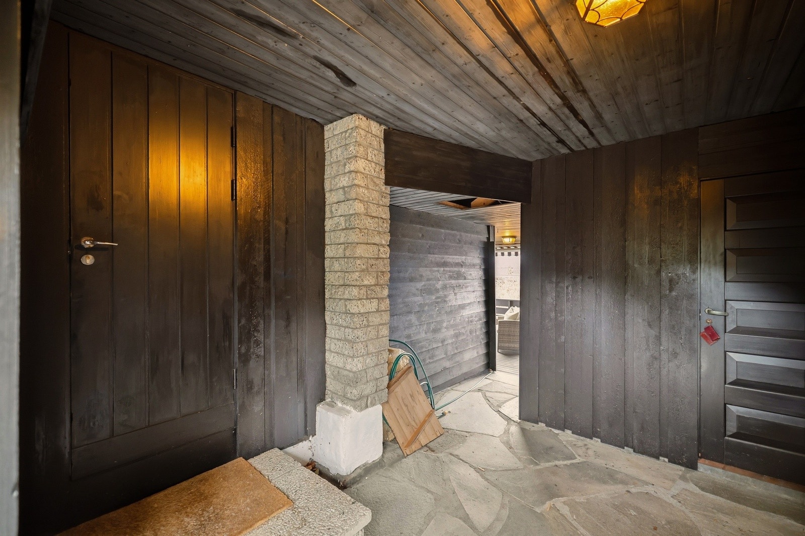 Overbygget areal som viser tilkomst fra garasjen til husets kjøkkeninngang | I bakre del av bildet ser du tilgangen til terrassen Galleribilde