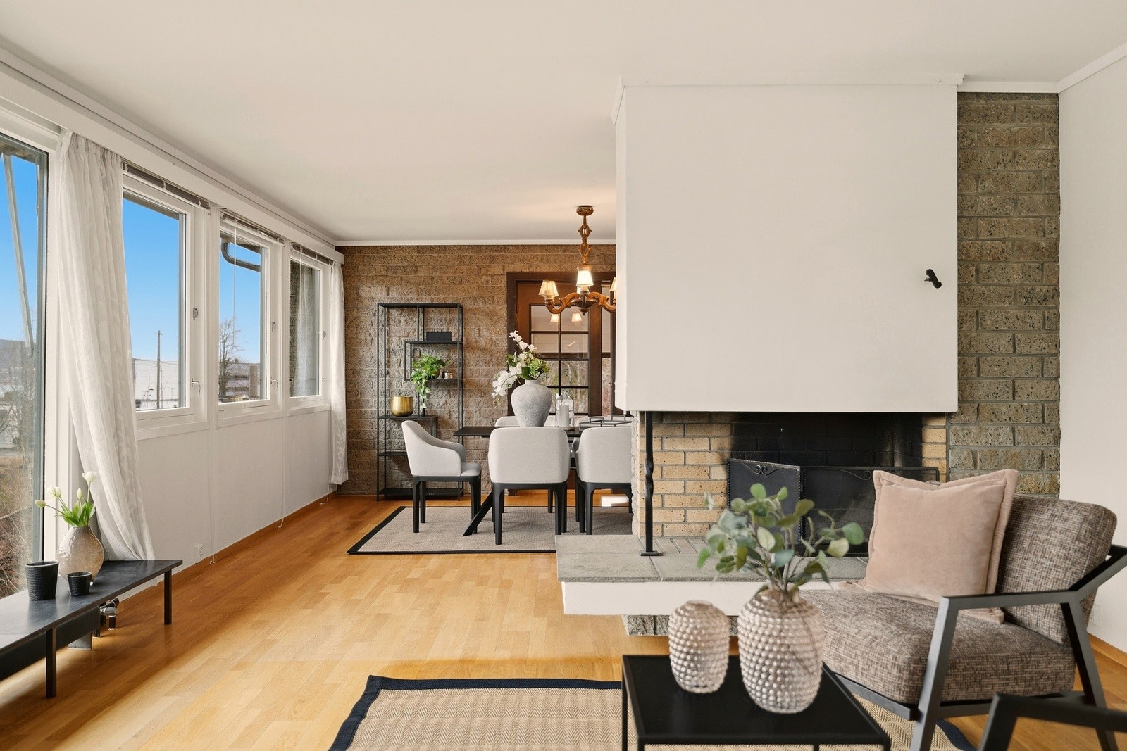 Peisen mot enden av stuen gir et fint skille mellom dagligstuen og spisestuen Galleribilde