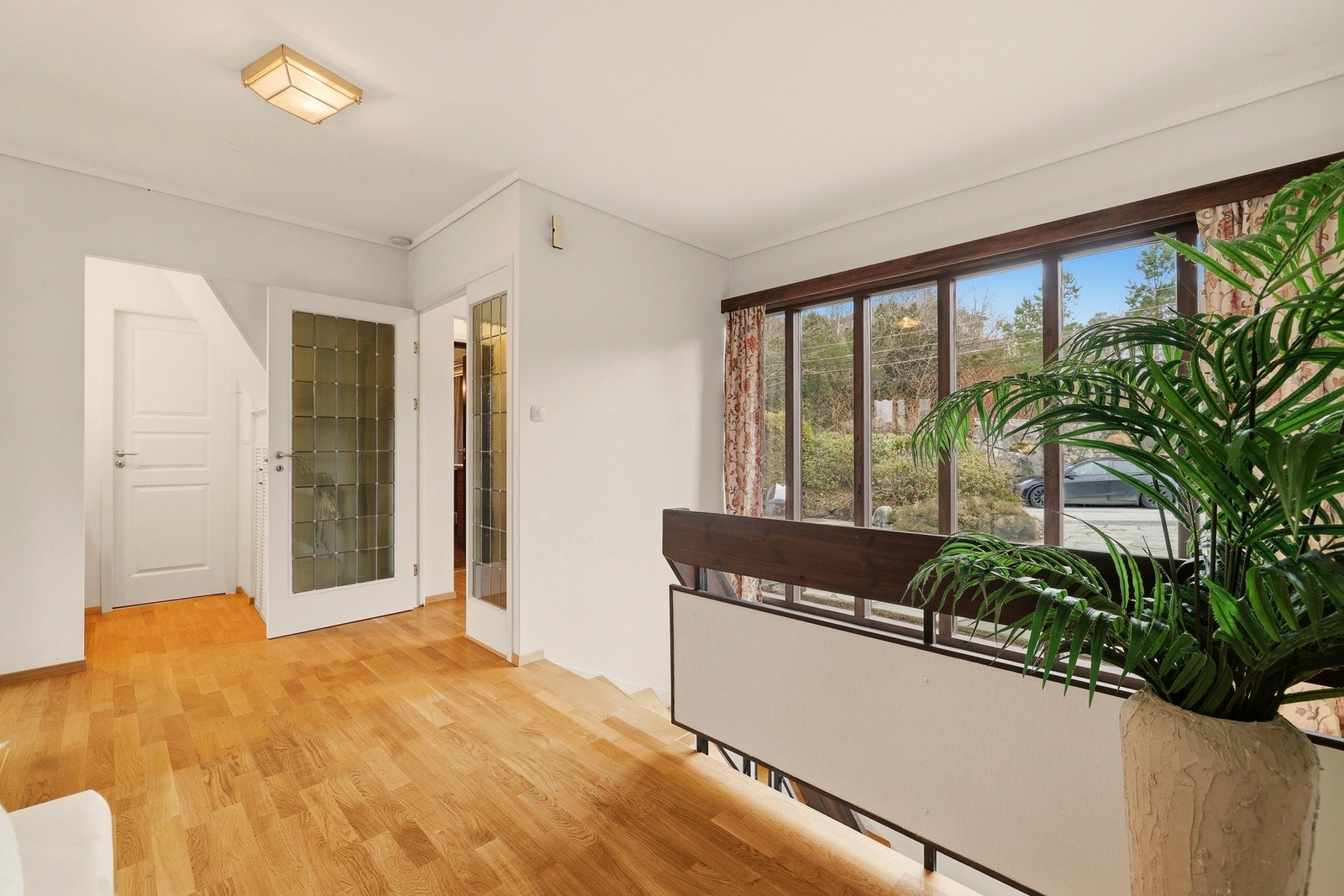 Den romslige hallen har store vindusflater ut mot innkjørsel og inngangsparti til boligen Galleribilde