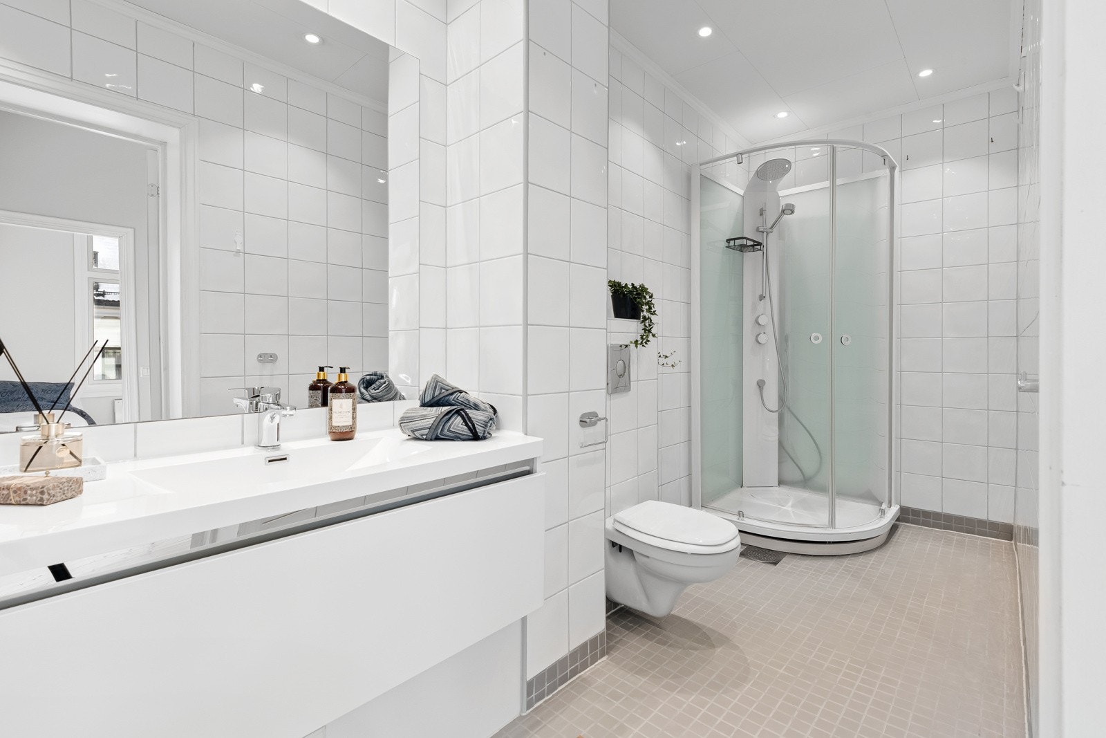 Lys innredning med romslige skap og skuffer, og badet har opplegg for vaskemaskin i praktisk nisje. Galleribilde