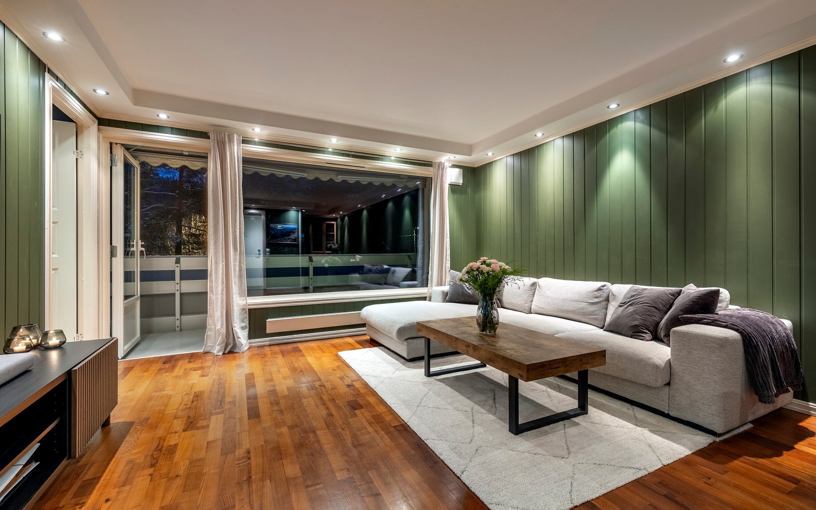 Stuen er romslig, malt i en frisk grønnfarge som er kombinert med parkettgulv. Galleribilde