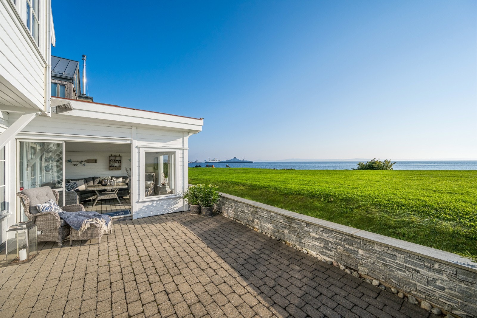 Her ser vi nedre plan av tomten med nok en steinsatt terrasse og hagestuen Galleribilde