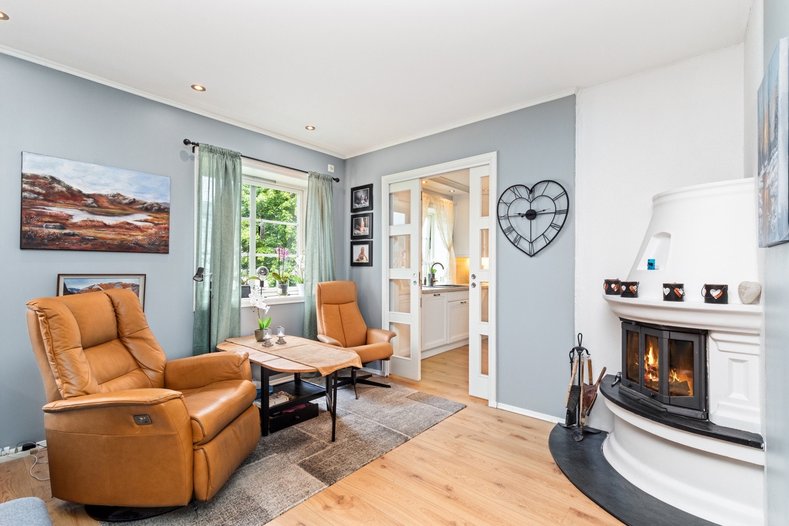 Stuen har flere soner. Nærmest kjøkkenet er det peisovn. Galleribilde