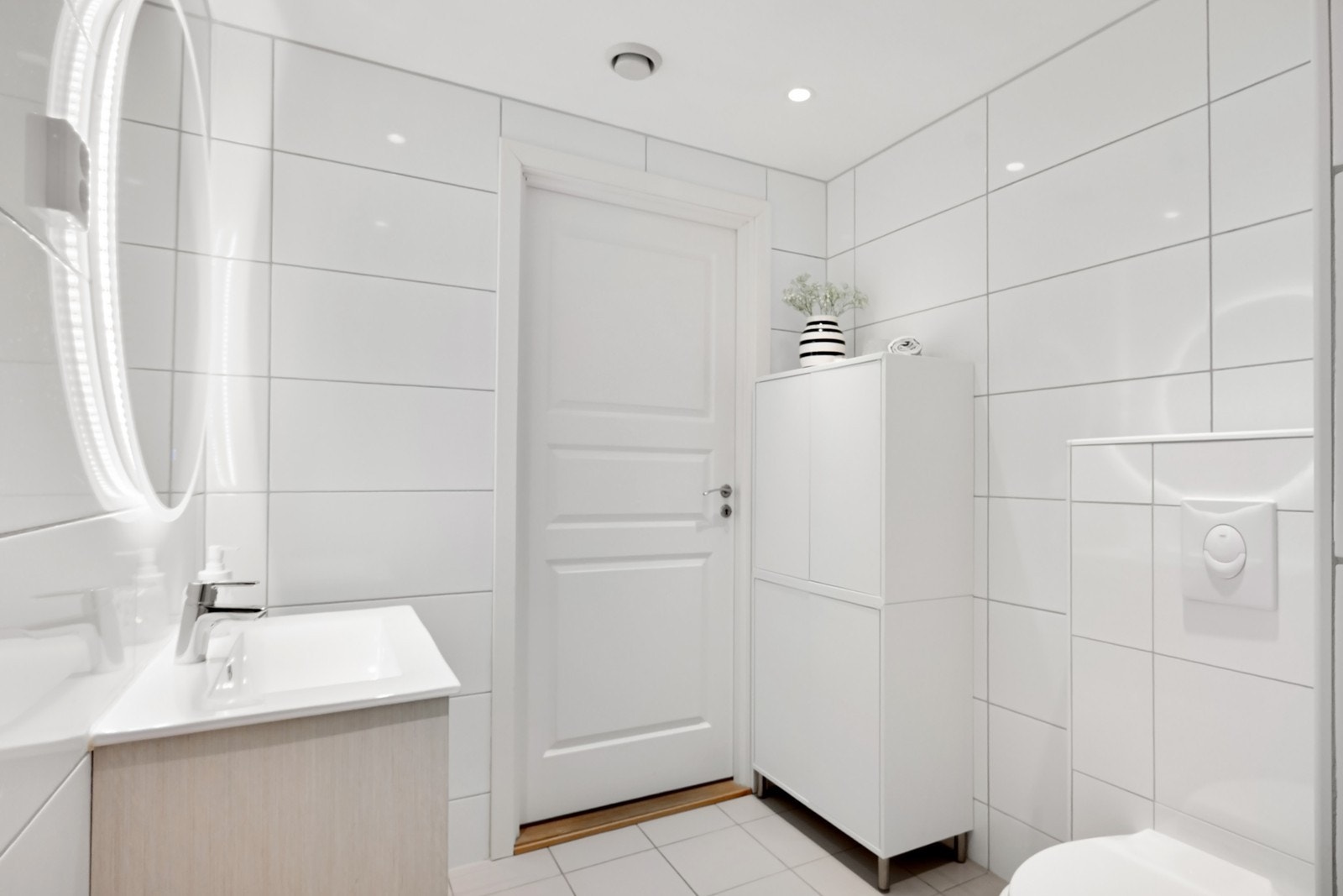 Innredningen består av vegghengt toalett, dusjnisje med svingbar glassdør, samt servant med god skuffeplass og speil med integrert belysning. Galleribilde