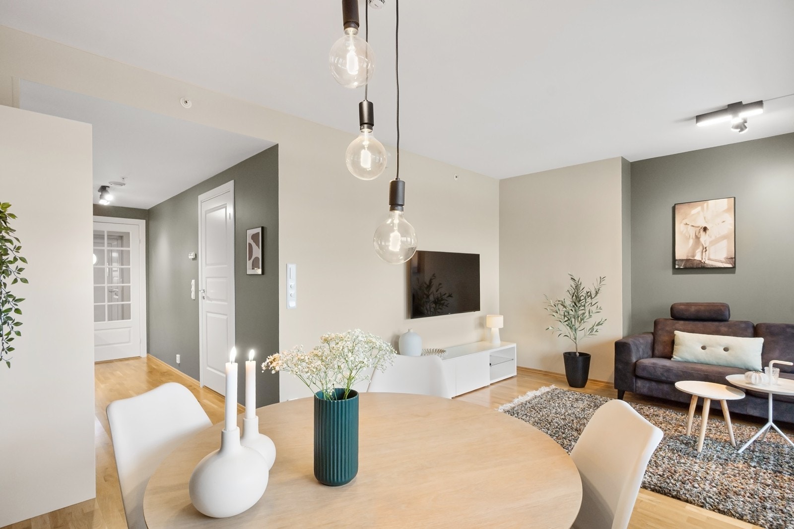 Stue og kjøkken ligger i åpen løsning og danner et lyst og sosialt oppholdsrom, med naturlige soner for både sofagruppe og spiseplass. Galleribilde