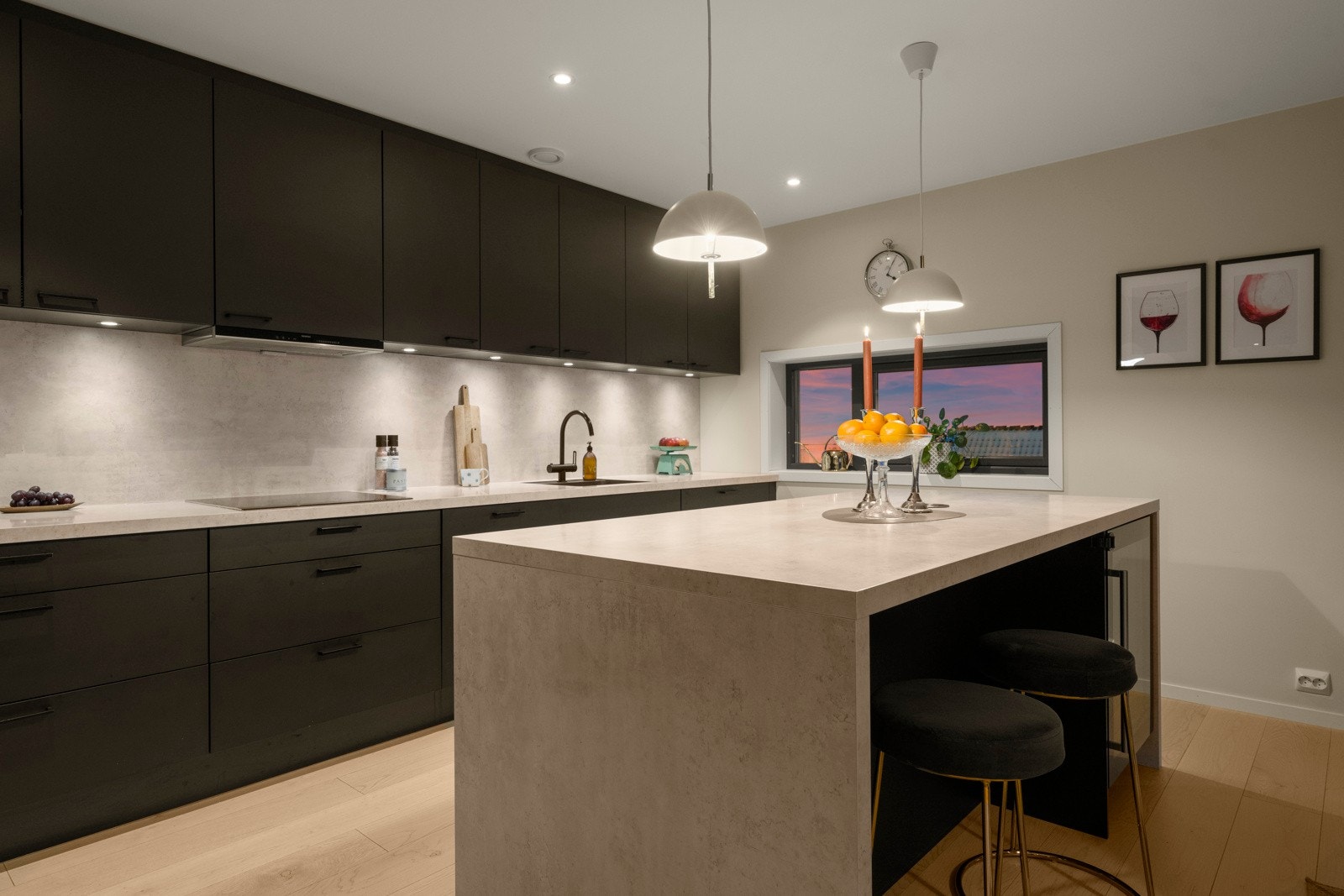 Det er praktisk belysning over benken, samt kjøkkenplate på vegg mellom overskap og kjøkkenbenk gir et stilfullt preg. Galleribilde