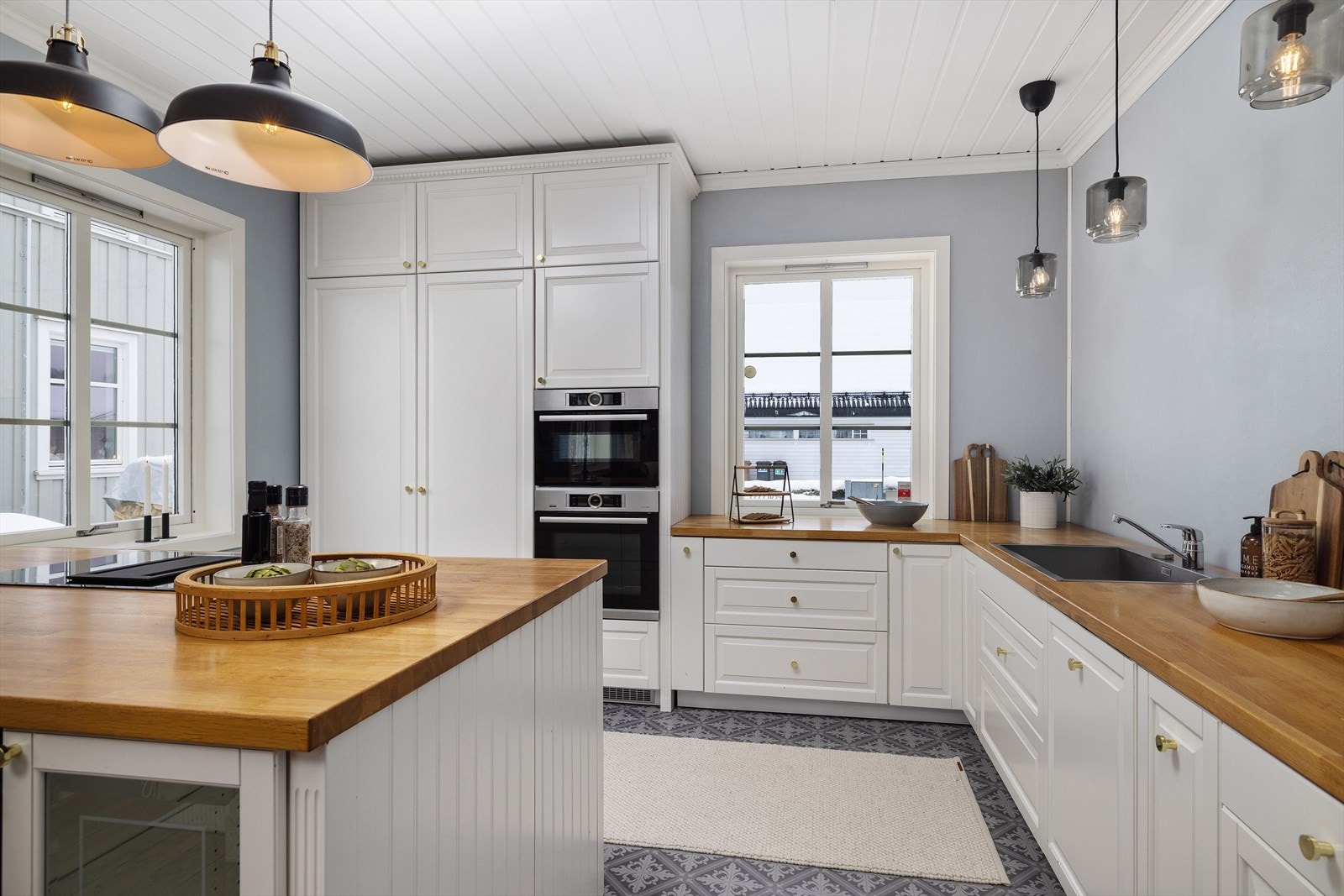 Her er det rikelig med lagringsplass i takhøye overskap, og alle hvitevarer er integrerte. Galleribilde