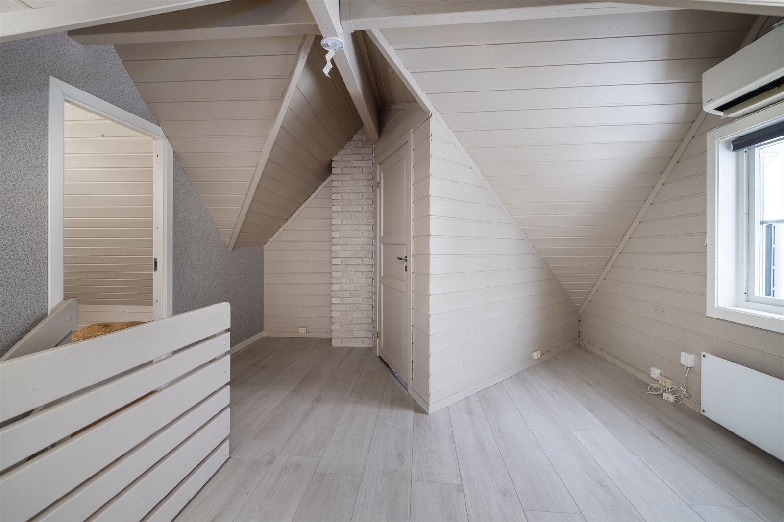 Trappen leder opp til en lys loftstue. Alle flater her ble malt og gulvet lagt med nytt laminat i 2022. Galleribilde