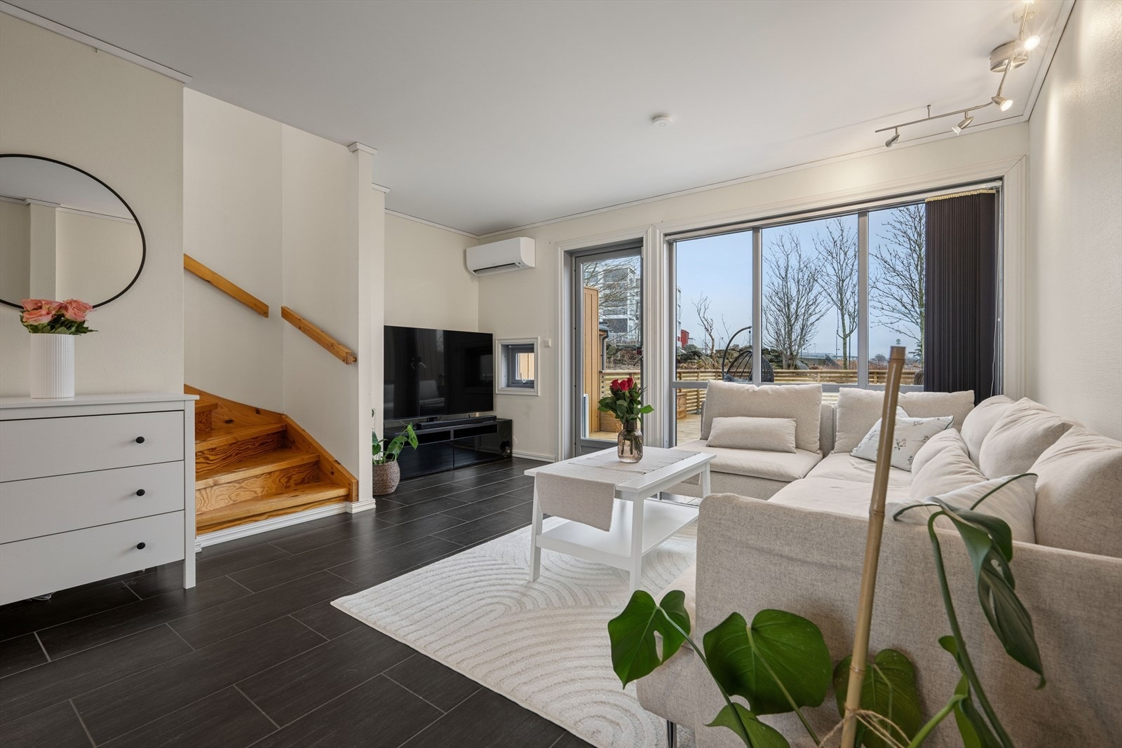 Lys stue med godt lysinnslipp fra generøse vindusflater. Direkte utgang til solrik markterrasse. Galleribilde