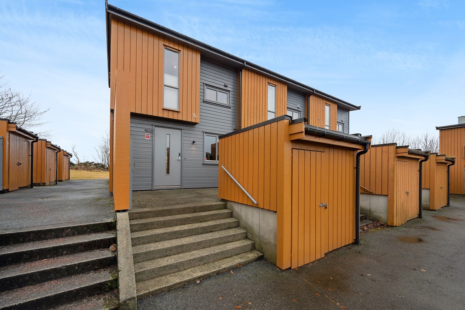 Steinbelagt inngangsparti med plass til utemøbler. Praktisk sportsbod på bakkeplan. Galleribilde