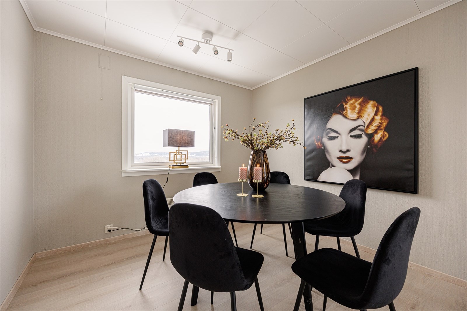 Malte overflater i en lun beige tone kombinert med laminatgulv i samme stil som kjøkkenet gir rommet et helhetlig og harmonisk uttrykk. Galleribilde