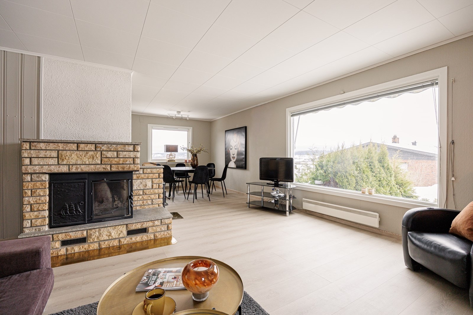 Lys stue med peis og store vindusflater som gir godt med naturlig lys og en åpen romfølelse. Galleribilde