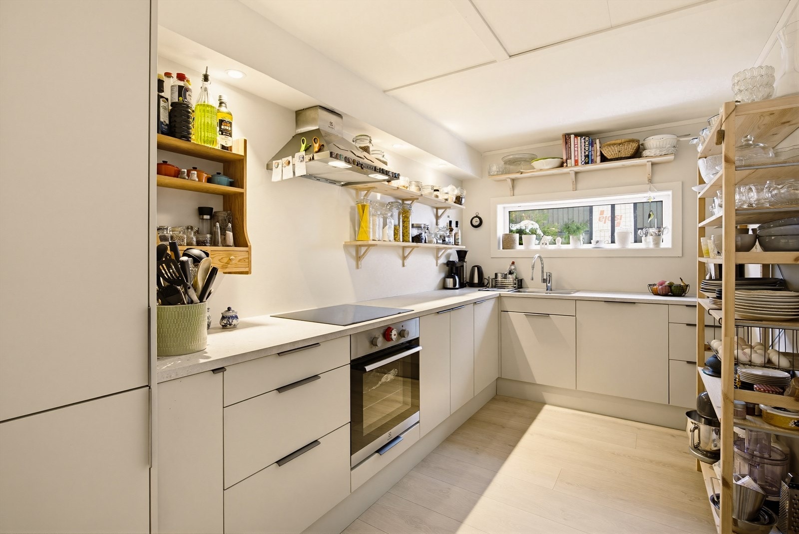 Moderne Epoq-kjøkken fra 2024 med glatte fronter, laminat benkeplate med nedfelt kum i rustfritt stål og integrerte hvitevarer. Galleribilde