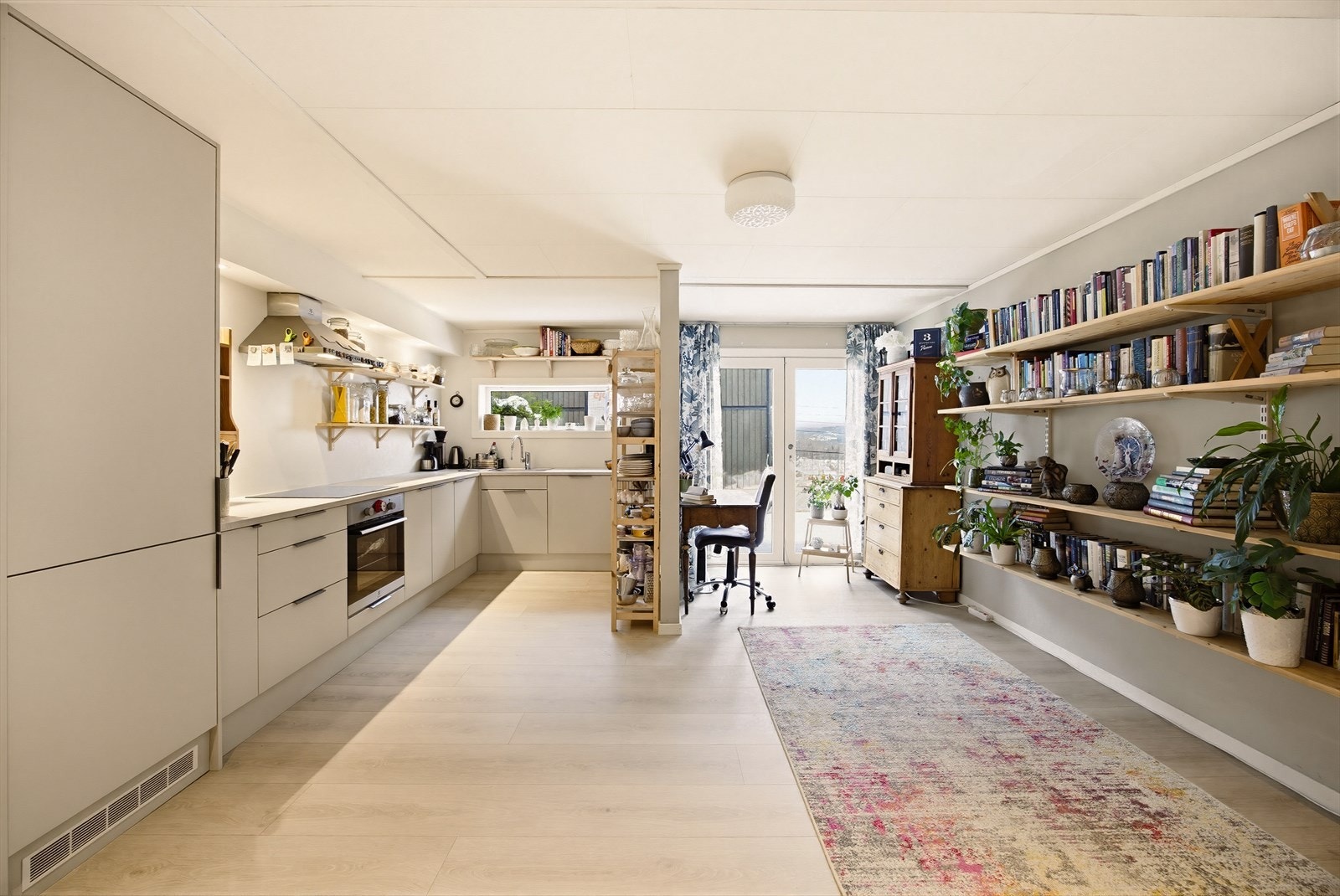 Underetasjen har stue og kjøkken i åpen sone, som skaper en sosial og luftig romfølelse. Laminatgulv og store vindusflater bidrar til et lyst og trivelig miljø. Galleribilde