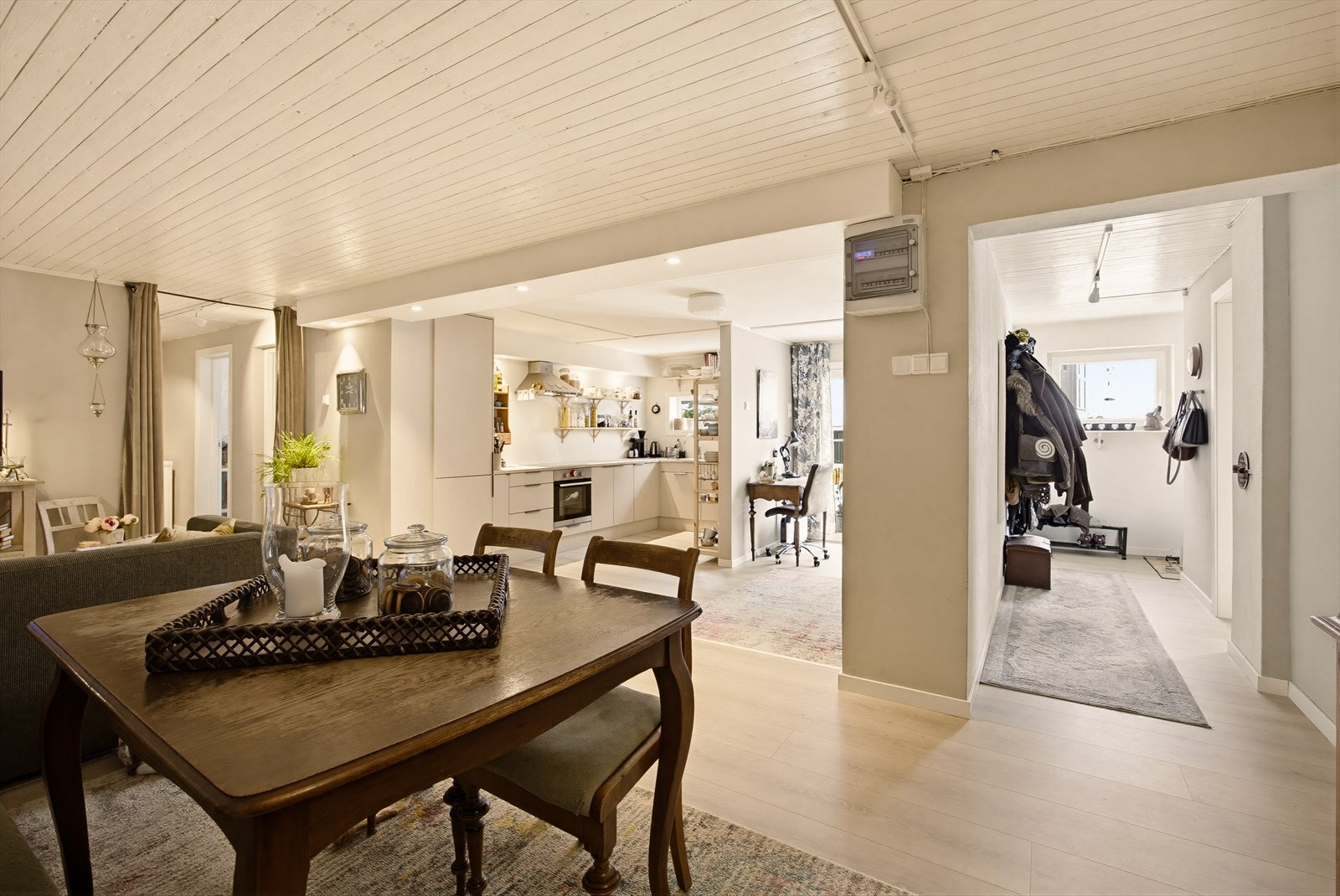 Rommet kan enkelt møbleres med både sofa-/TV-sone og spiseplass, med terrassedører som slipper inn rikelig med naturlig lys. Til høyre ser du enteén. Galleribilde