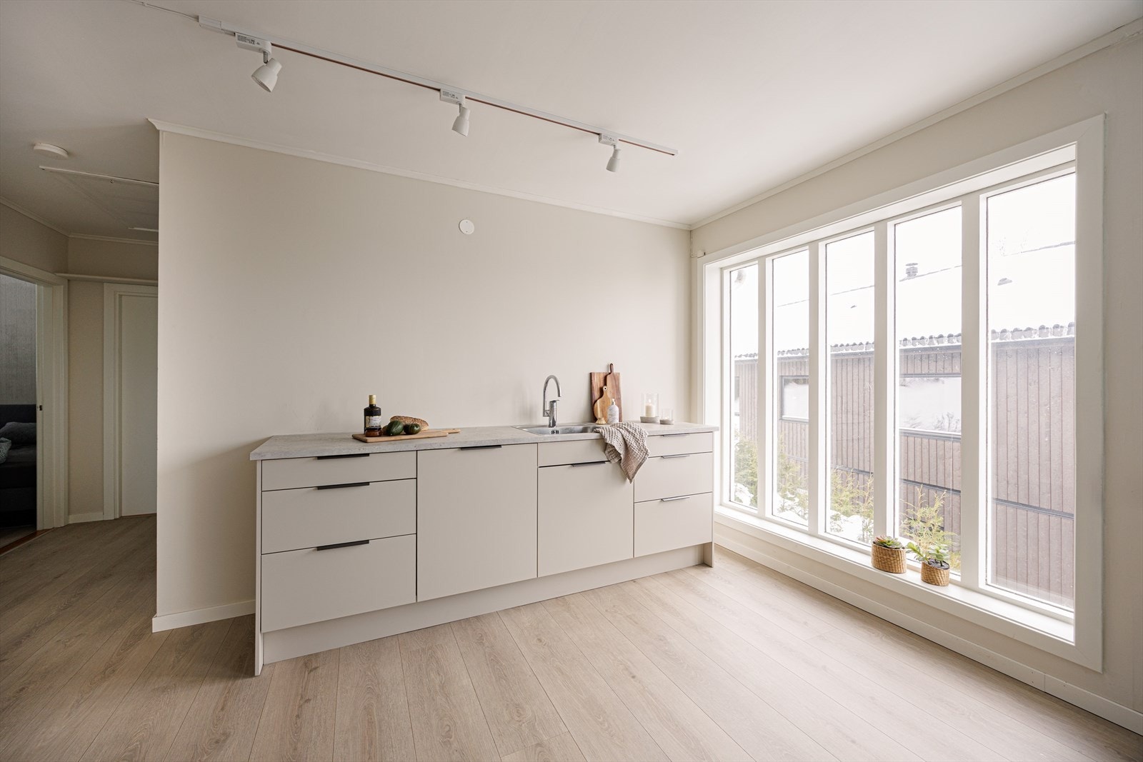 Store vindusflater slipper inn rikelig med naturlig lys og gir rommet en lys og innbydende atmosfære. Galleribilde