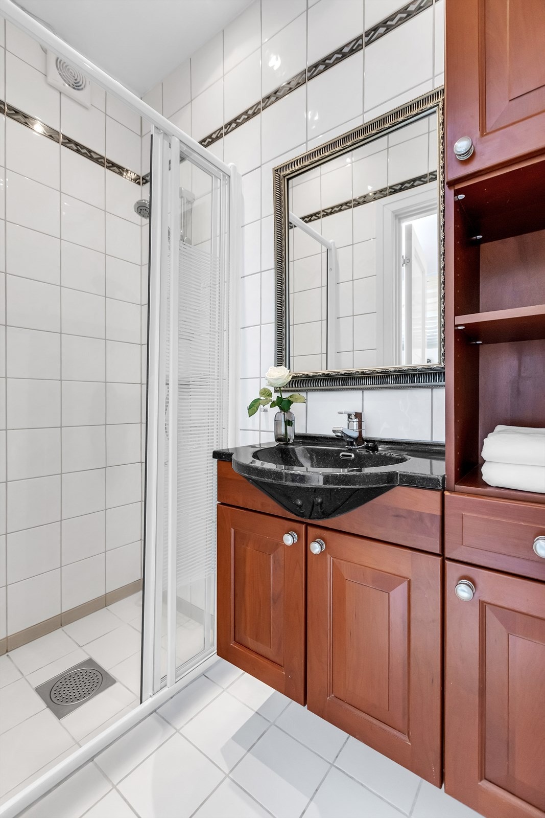 Badet er flislagt i lyse, tidløse fliser som er praktisk og funksjonelt. Galleribilde