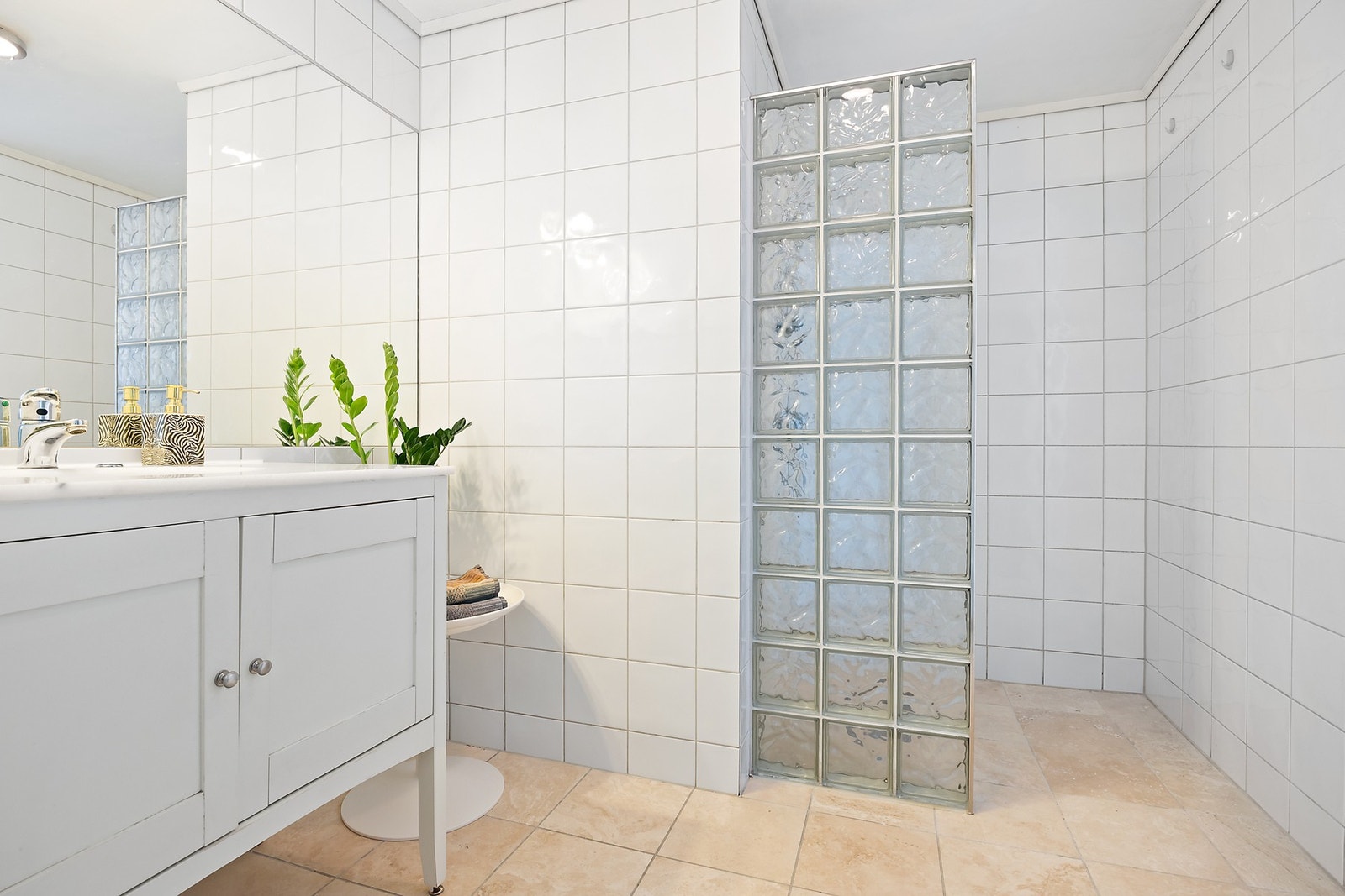 Flislagt baderom innredet med dusjnisje og servant med servantskap. Galleribilde