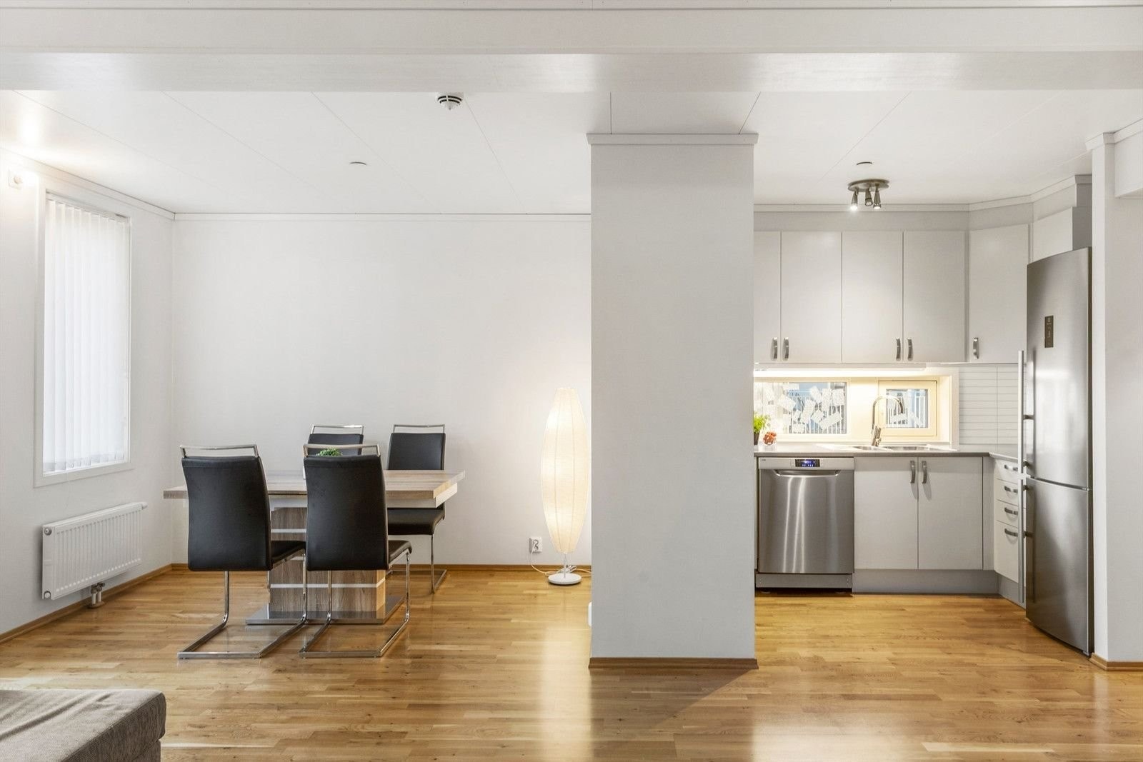 Den åpne planløsningen mellom stuen og kjøkkenet er både innbydende og praktisk, samtidig som kjøkkenet oppleves adskilt Galleribilde