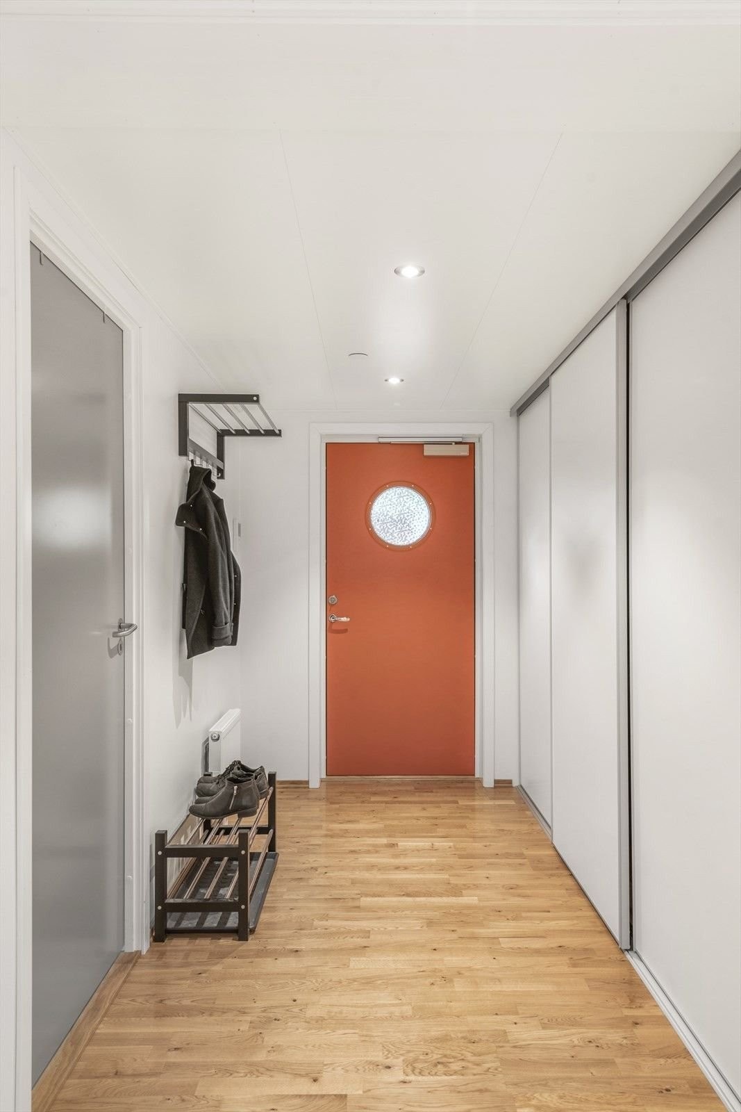 Bak inngangsdøren blir man møtt av en lys entre og gang med dør inn til alle rom i leiligheten Galleribilde