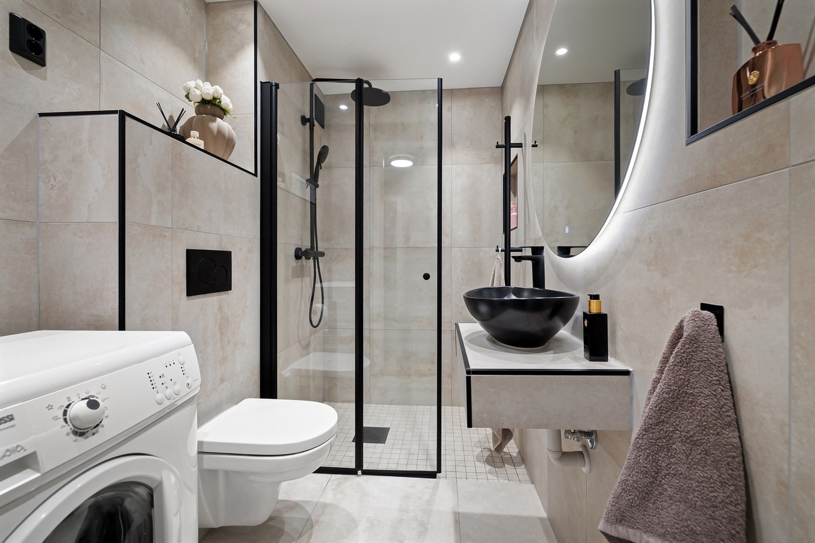 Pent og meget romslig bad med fliser på gulv- og veggflater med varme i gulv og downlights i himling Galleribilde