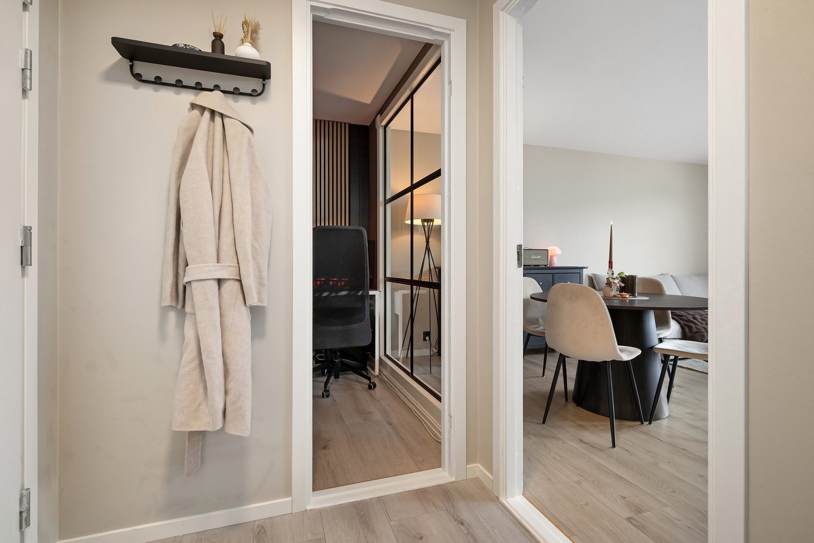 Med direkte adkomst fra entreen er det etablert et kontor med garderobeløsning og dekorativt glassvindu mot stuen Galleribilde