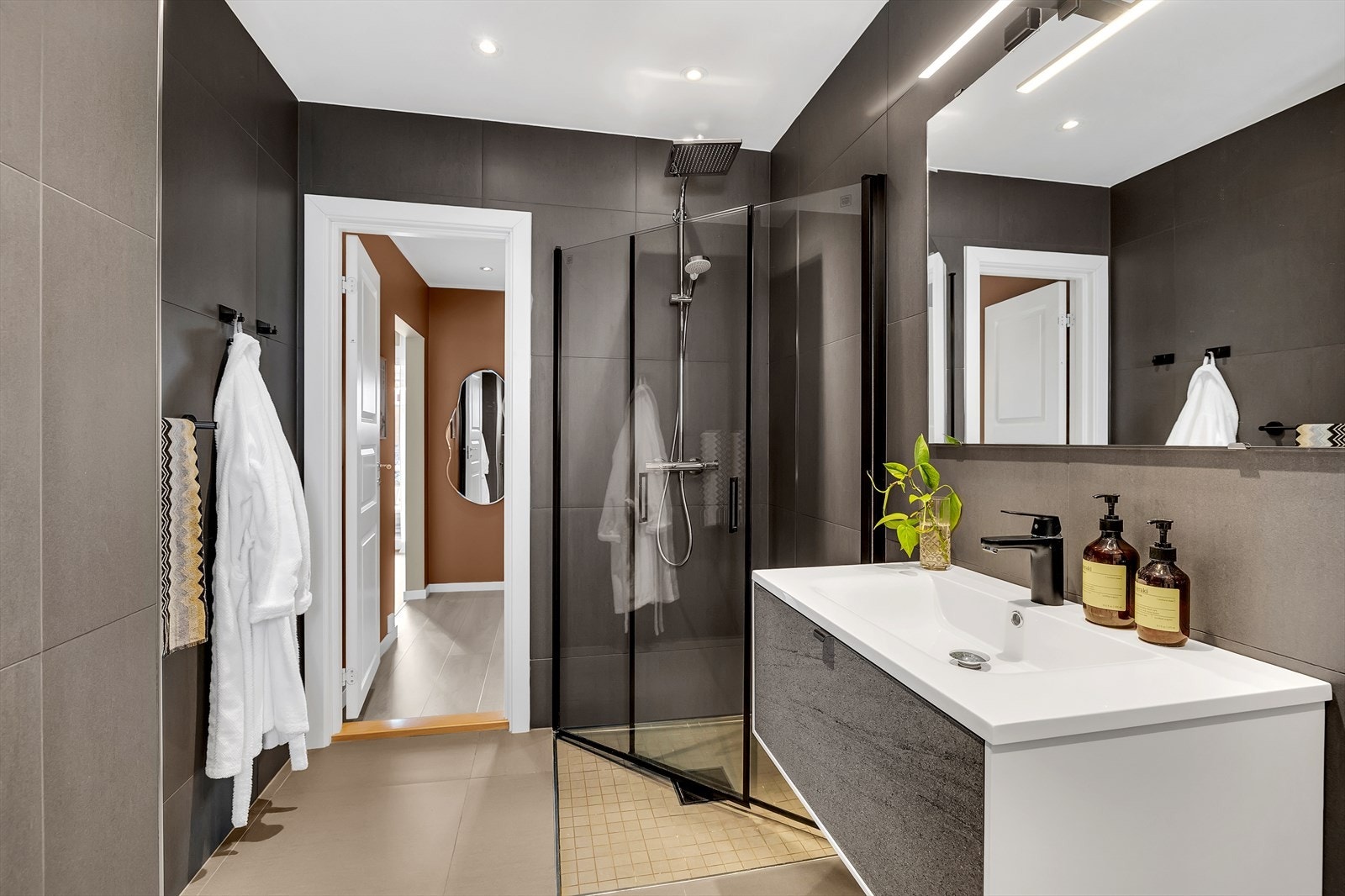 Dusj med innfellbare glassvegger og moderne armatur gir en stilren dusjløsning. Galleribilde