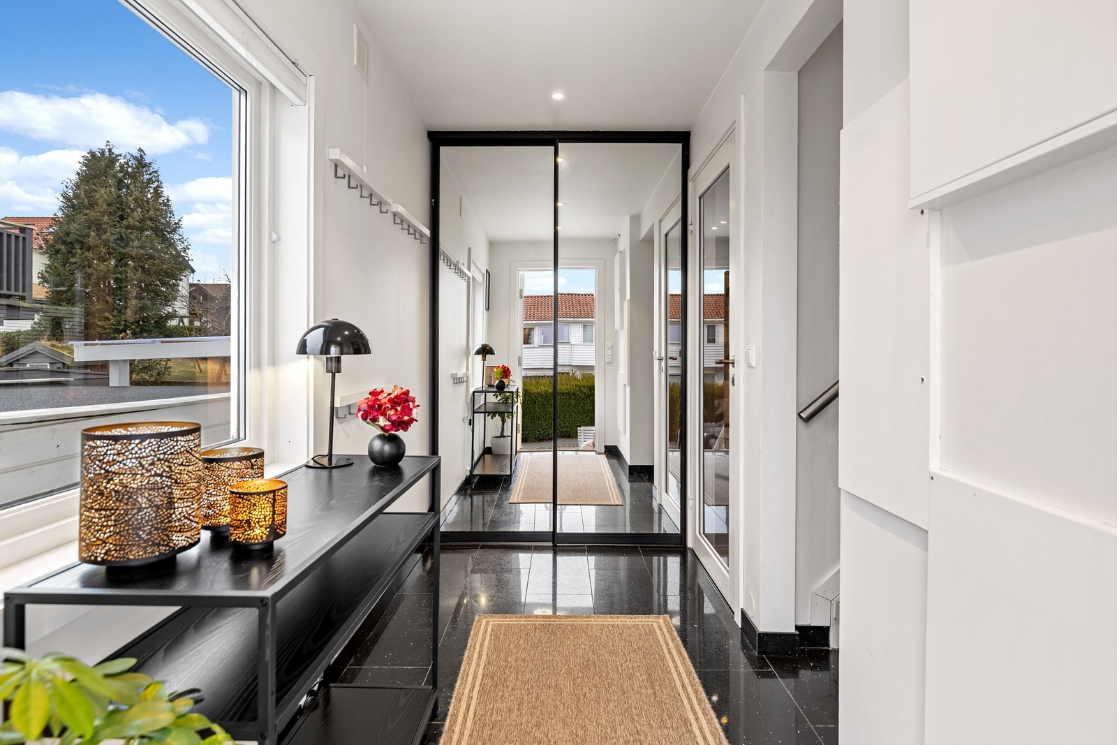 Gangen har flislagt gulv og skyvedørsgarderobe for oppbevaring av yttertøy og sko. Galleribilde