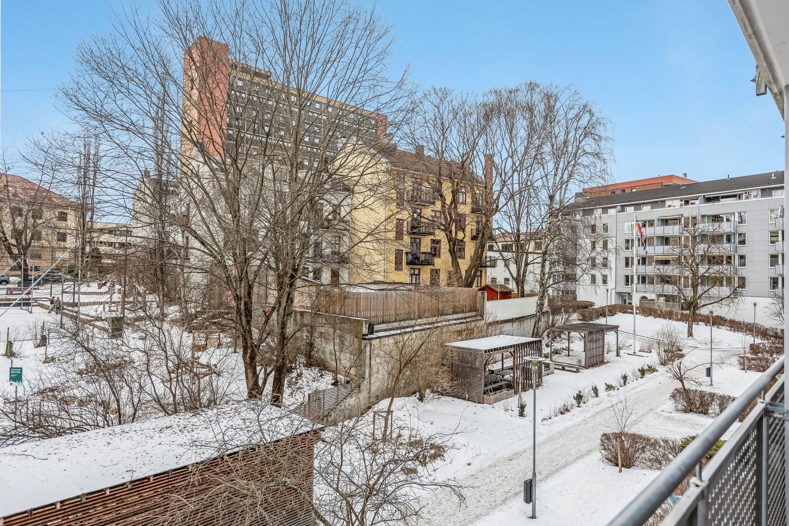 Utsikt fra balkong mot bakgård. Pergola, sittegrupper og grillplass kun tilgjengelig for sameiets beboere. Galleribilde