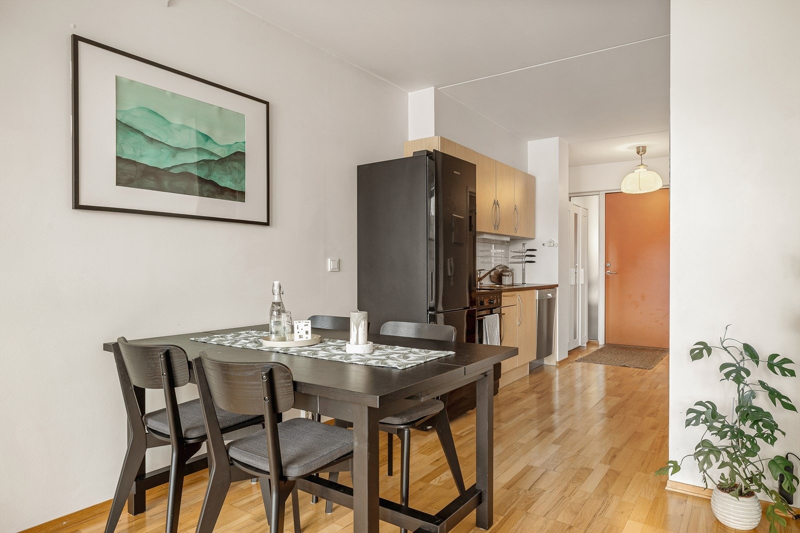 Delvis åpen stue-/kjøkkenløsning med naturlige soner, der sofakroken er naturlig adskilt fra kjøkkenet. Galleribilde