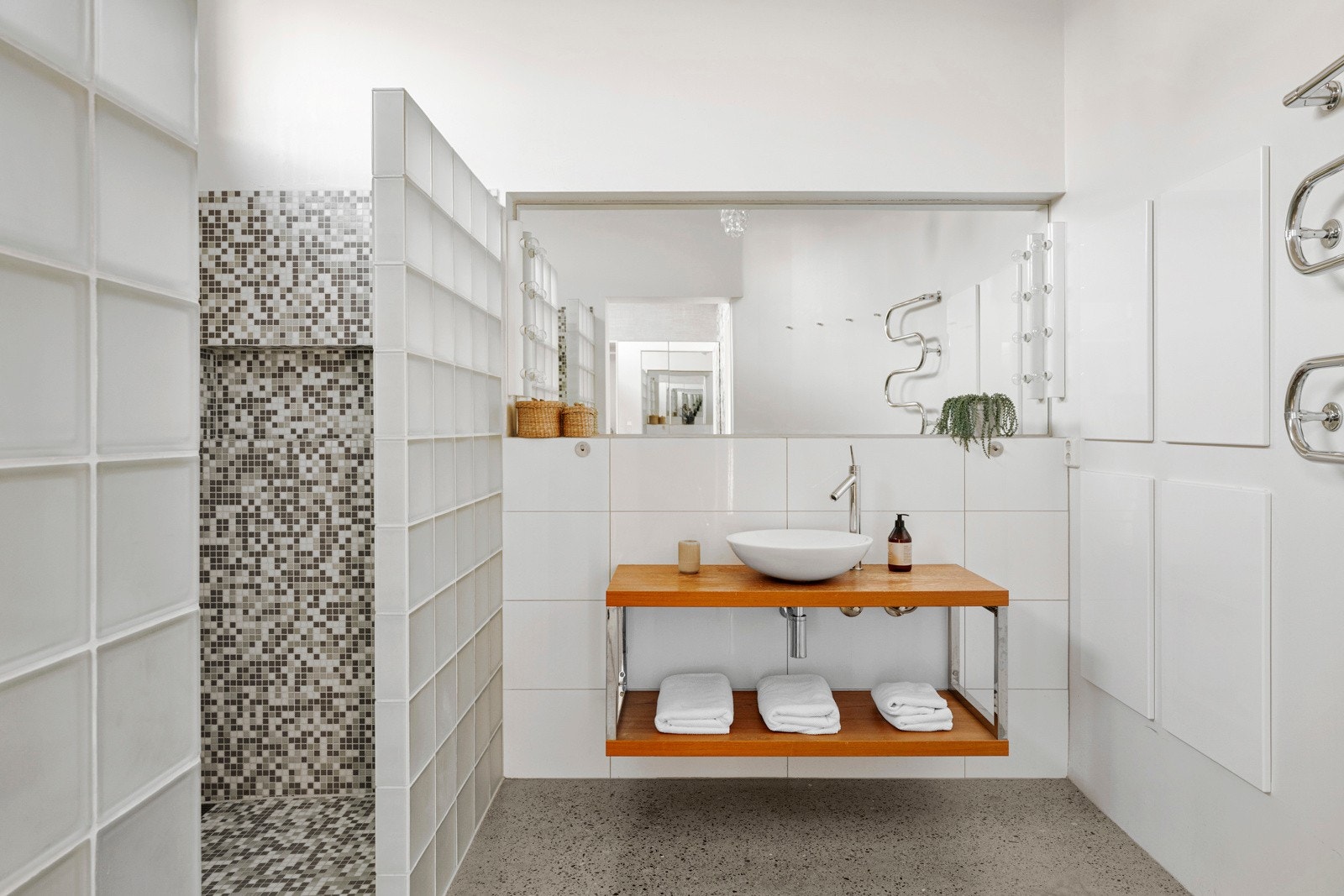 Badet i soveromsavdelingen er av god størrelse og er praktisk inndelt med en glassvegg som skaper en naturlig oppdeling av rommet. Galleribilde