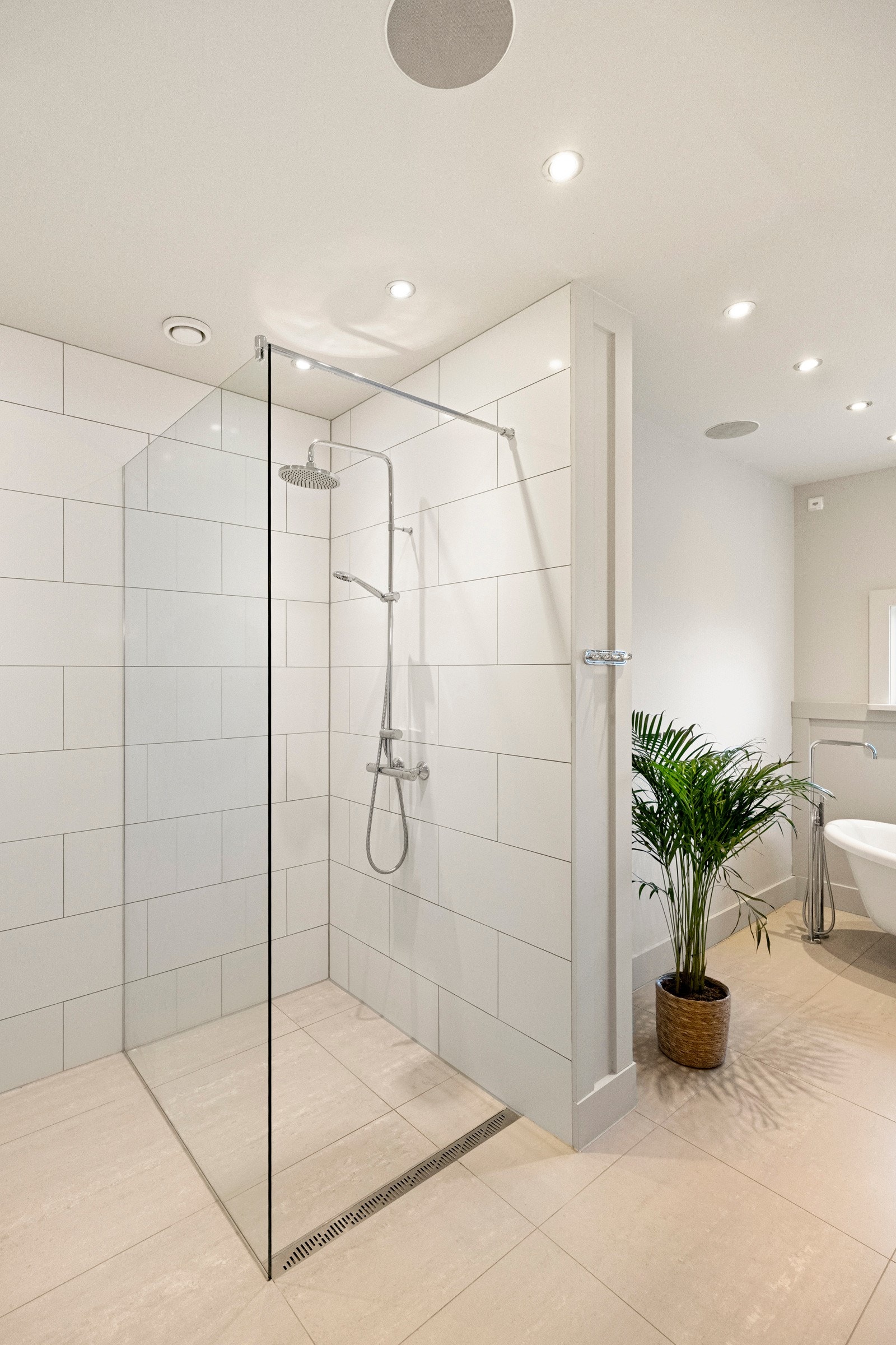 Rommet er videre innredet med frittstående toalett, stort speil, badekar og et separat dusjhjørne med glassdør og regndusj. Galleribilde