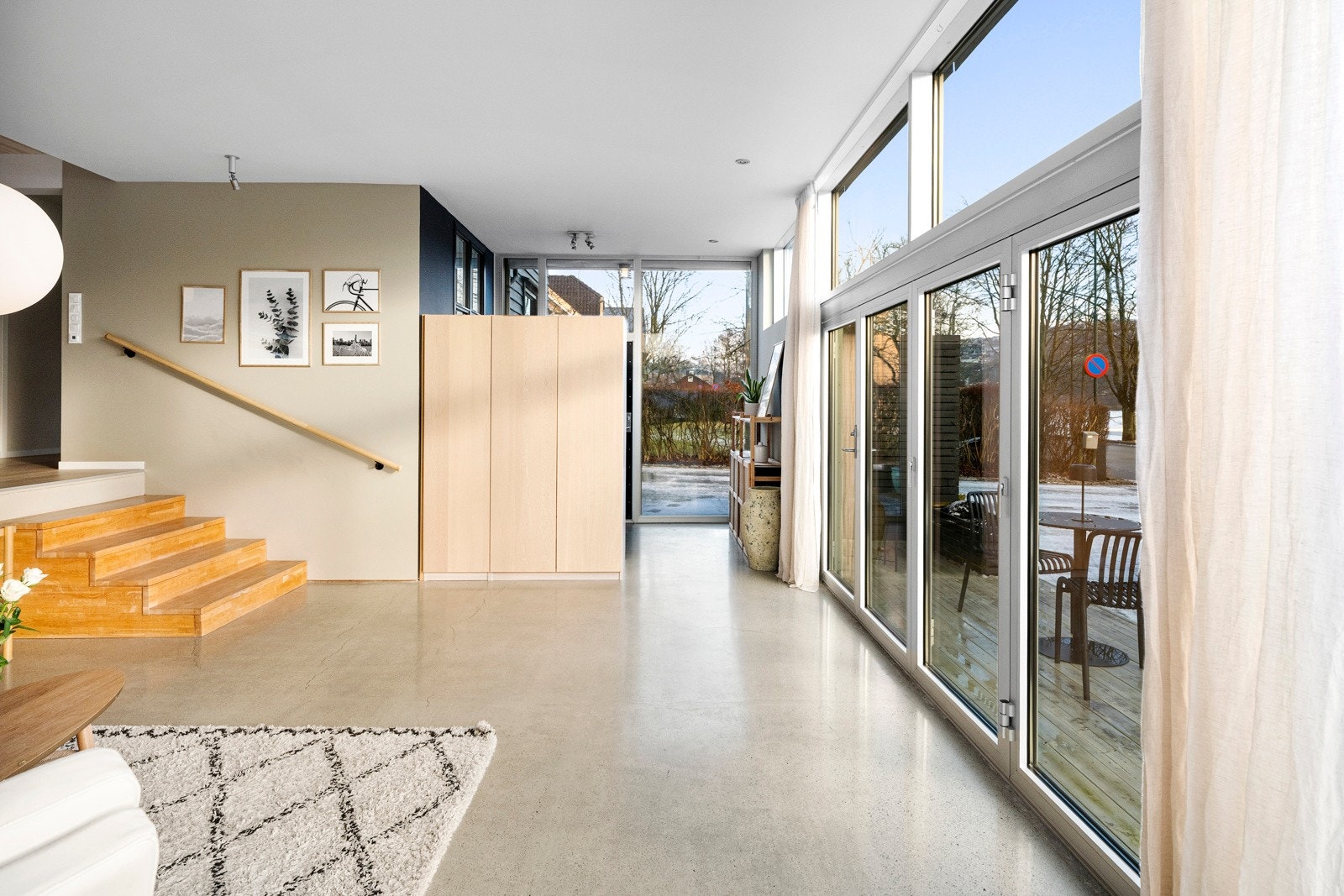 Her er det montert et stort, dobbeltsidig skap som skaper en naturlig avskjerming mellom gang og stue. Galleribilde