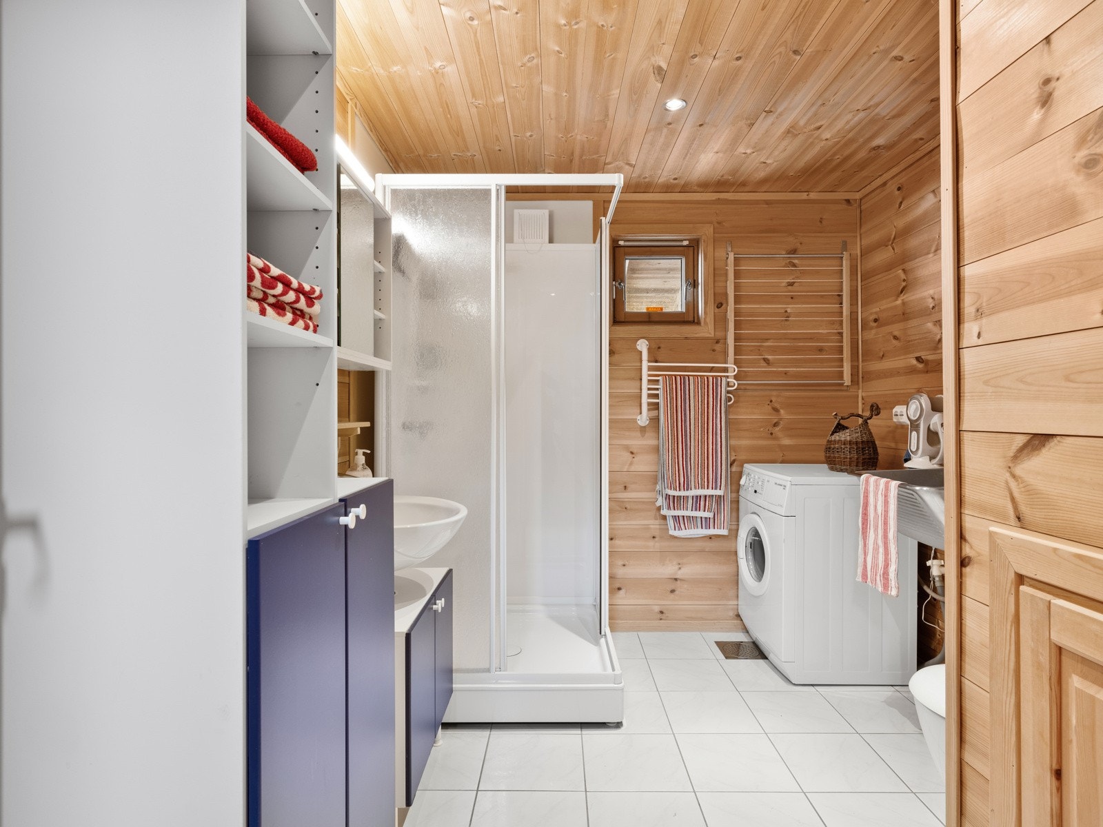 Baderommet er funksjonelt, med flislagt gulv og malte plater på veggene i dusjsonen. De øvrige veggene er kledd med panel, som gir rommet en varm og koselig atmosfære. Galleribilde