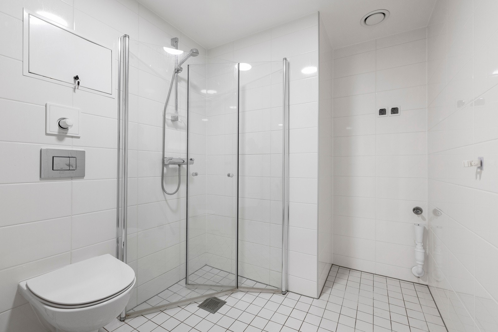 Veggmontert toalett og dusjhjørne med inntrekkbare glassdører Galleribilde