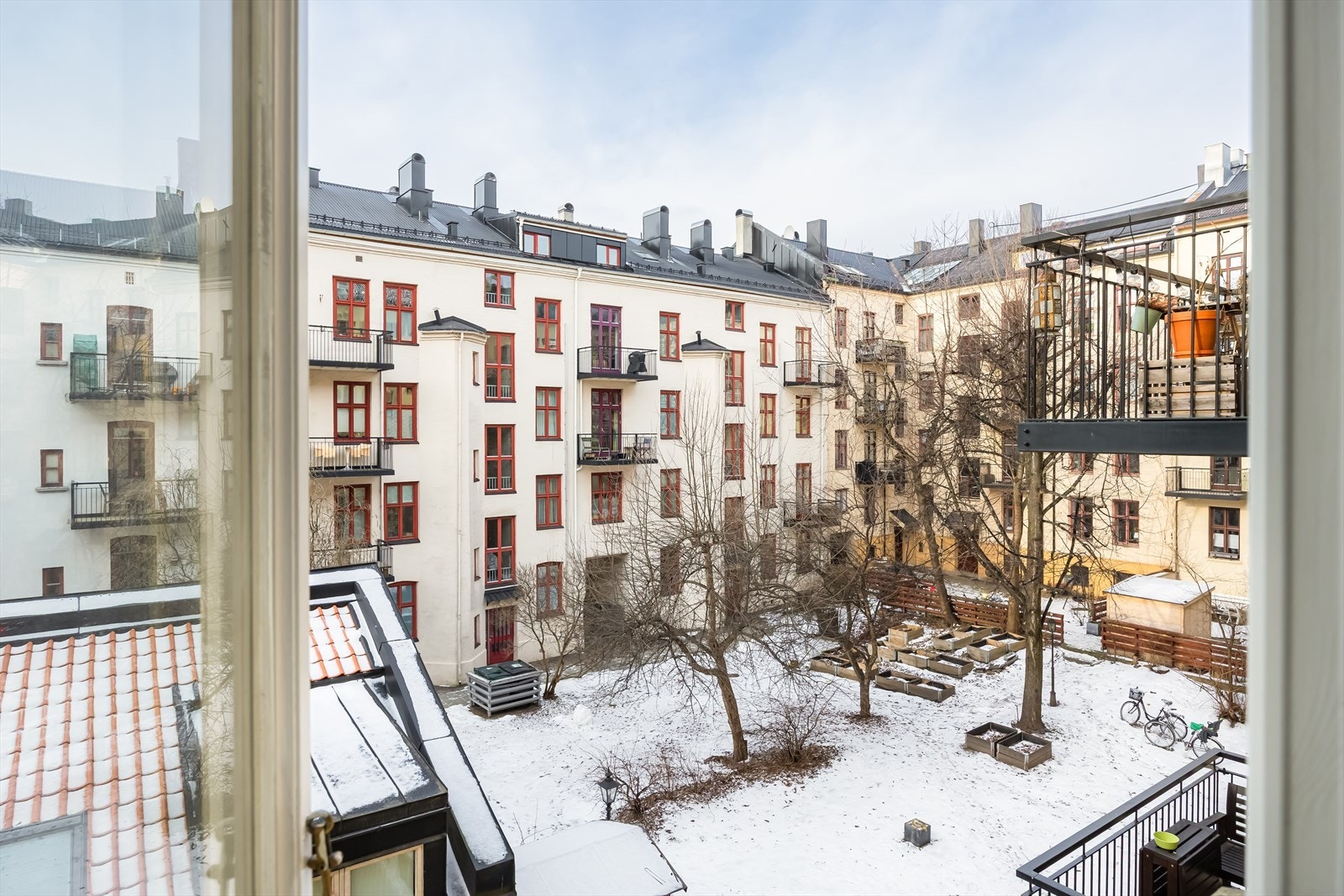 Utsikt mot skjermet bakgård med belegningsstein og beplantning, ideelt for felles bruk. Galleribilde