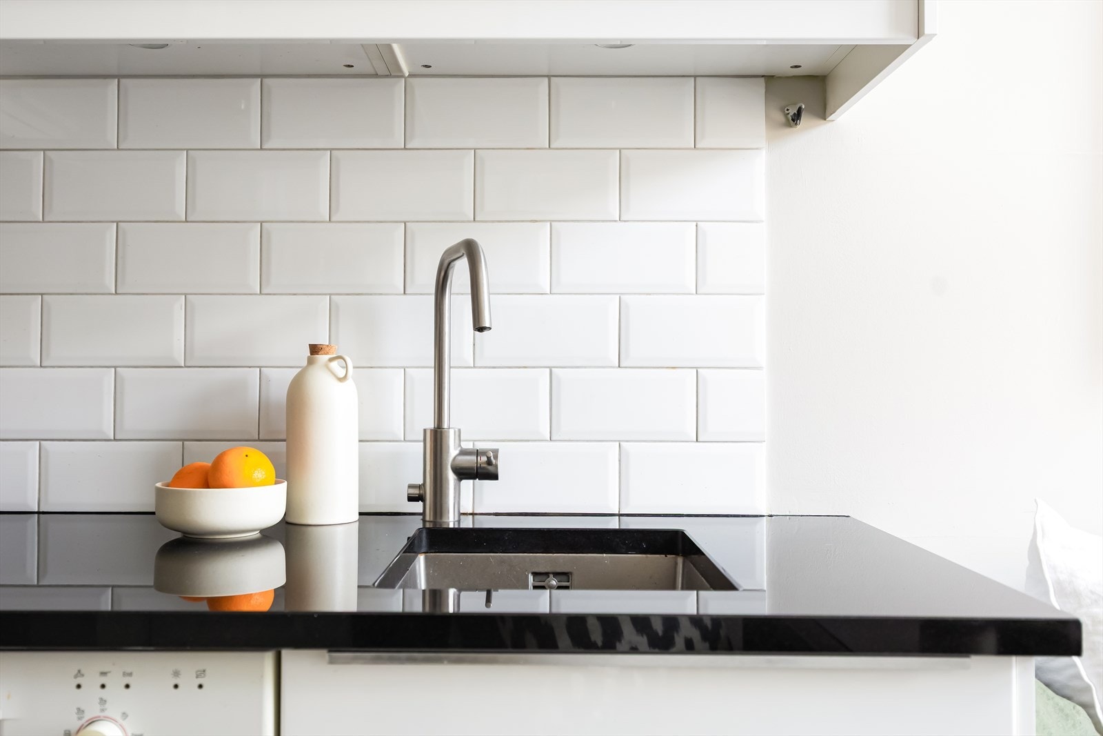 Fliser i benkerygg og belysning under overskap. Galleribilde