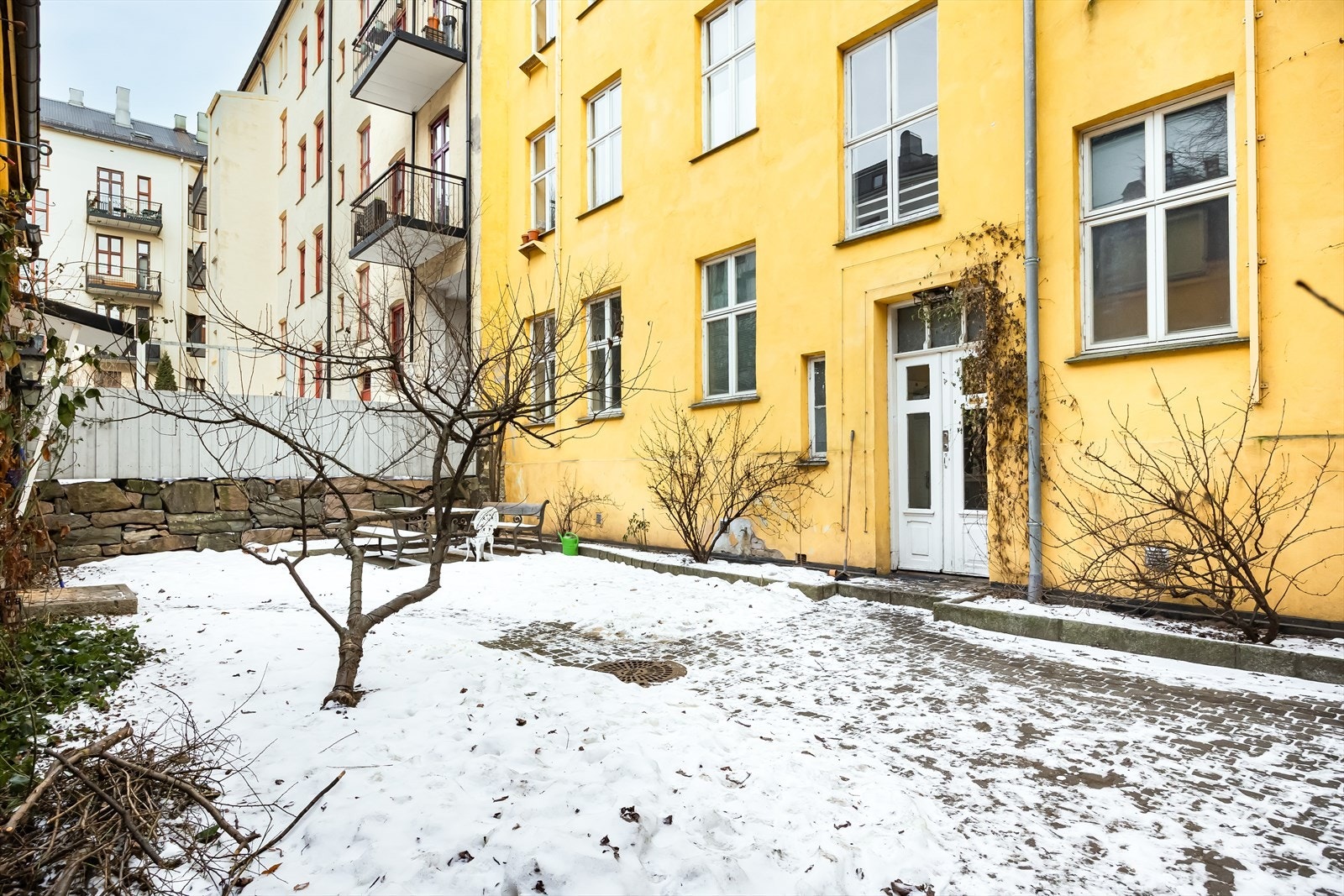 Bakgården er fint opparbeidet med belegningsstein og trær, skaper et innbydende miljø. Galleribilde