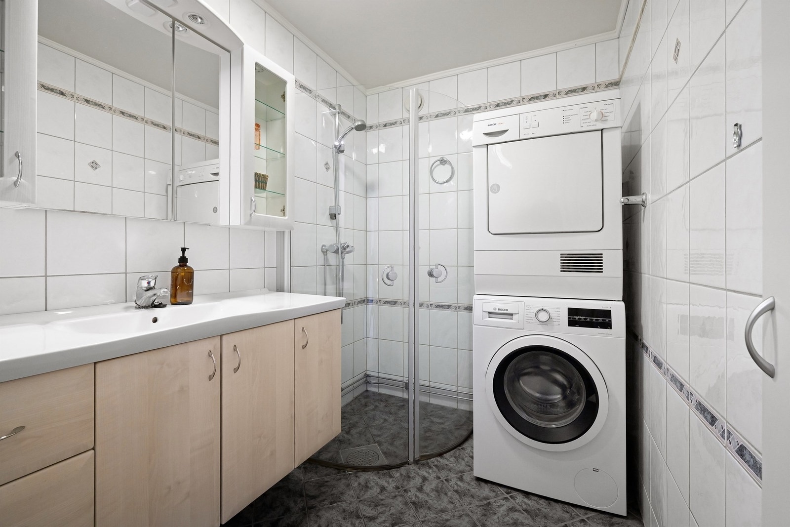 Flislagt baderom med gulvvarme og både opplegg og plass til vaskemaskin og tørketrommel Galleribilde