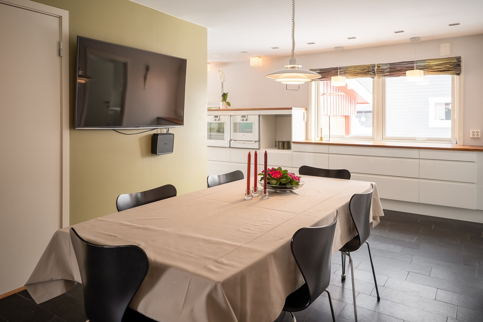 Videre inn til kjøkken har man et stort allrom med plass til spisebord. Det er lagt opp høyttalere i tak til info. Galleribilde