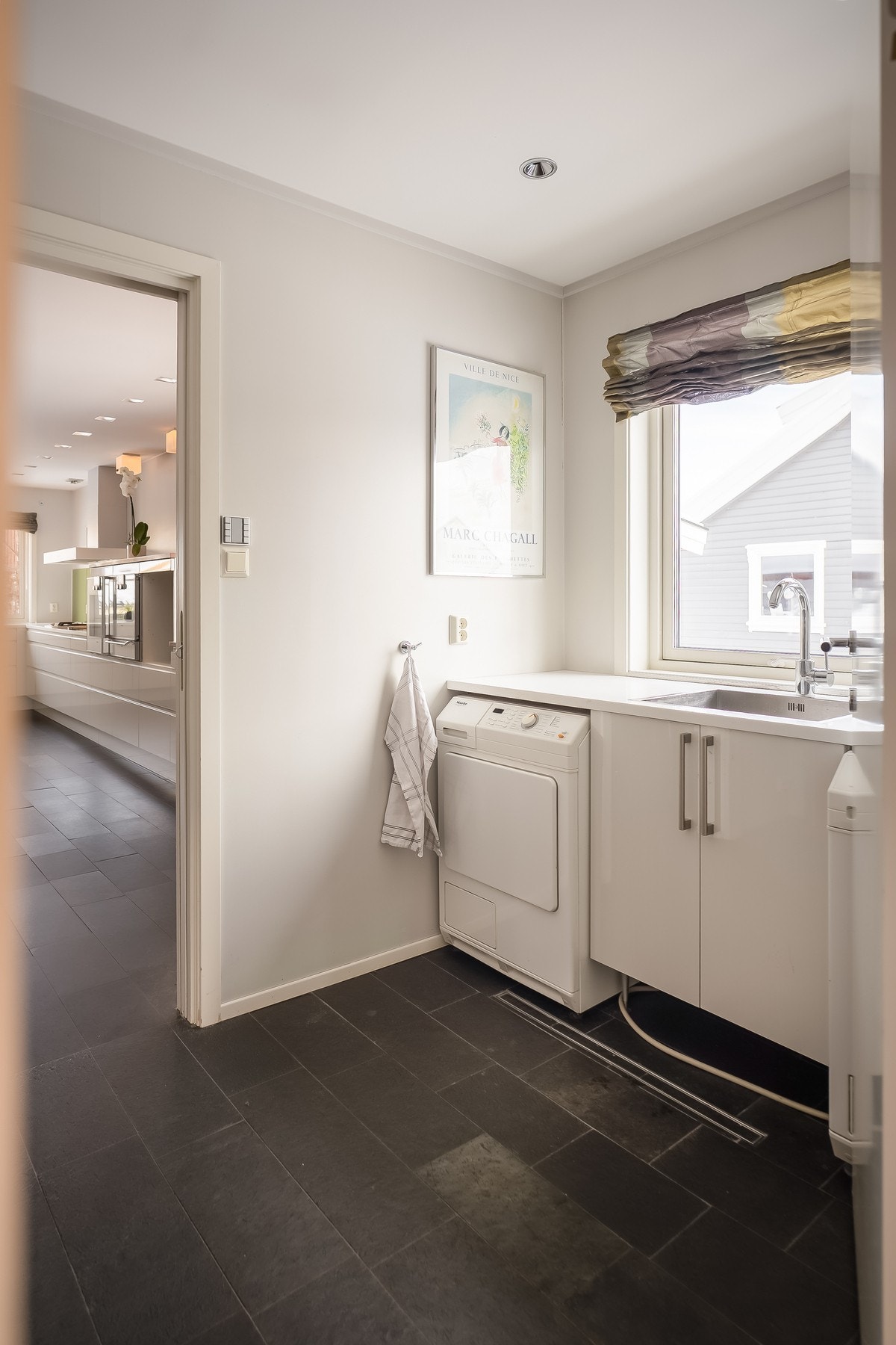 En funksjonell planløsning hvor man kan gå rett fra inngang, igjennom vaskerom og til kjøkkenet. Gjester ankommer heller via hallen og til stuen. Galleribilde