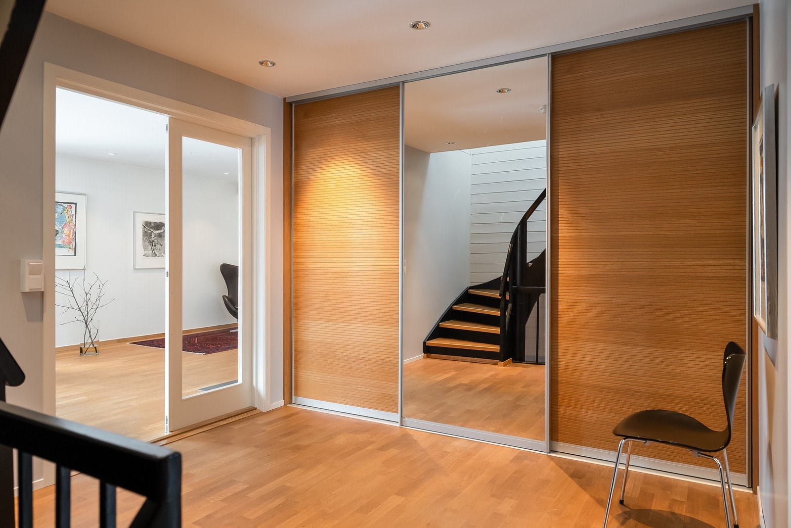 Svært romslig hall med skyvedørsgarderobe som leder inn i stuen. Her er også trappen som går opp til loft og ned til kjeller. Galleribilde