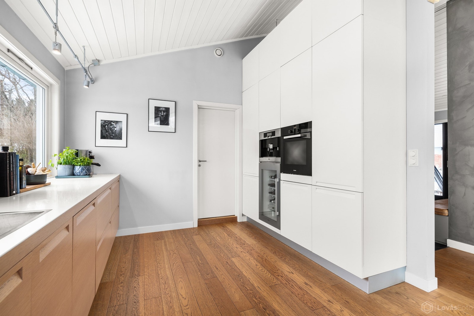 Høyskapene rommer integrerte hvitevarer, inkludert stekeovn, kaffemaskin og vinskap. Galleribilde